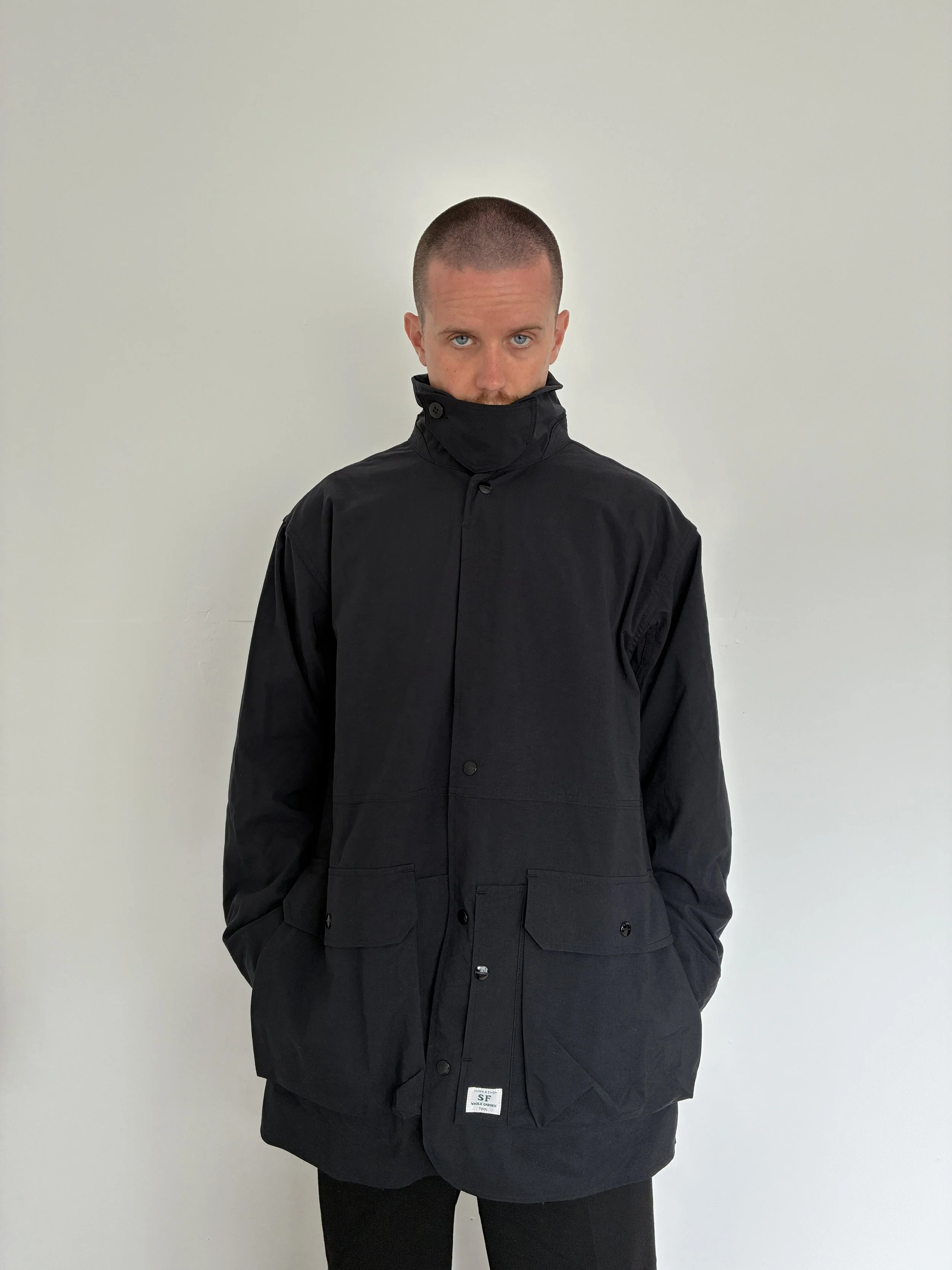 Man wearing Black Sassafras Cultivator Coat buttoned up
