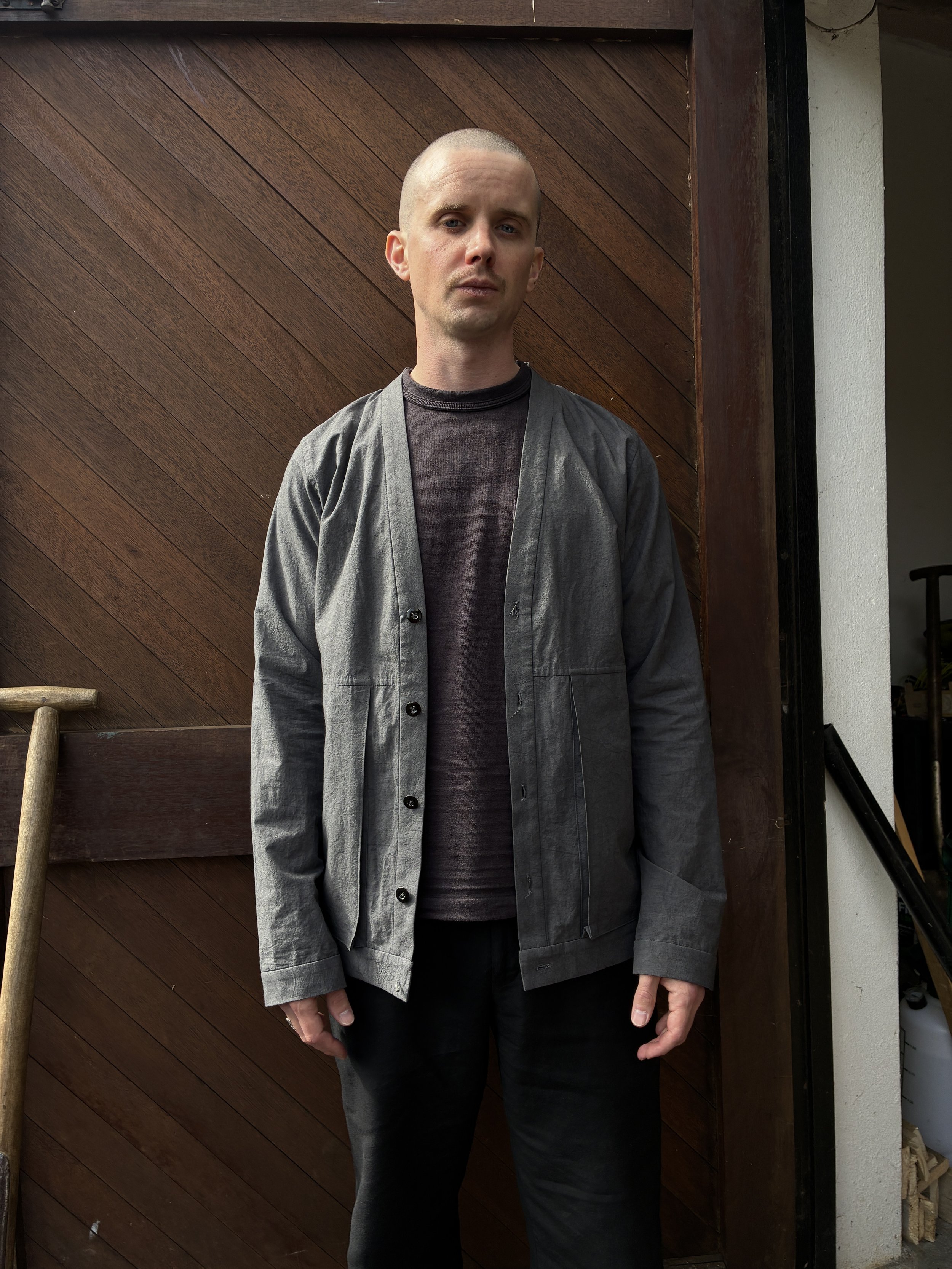 Man in front of wooden door wearing Frank Leder Grey Japanese Cotton Cardigan
