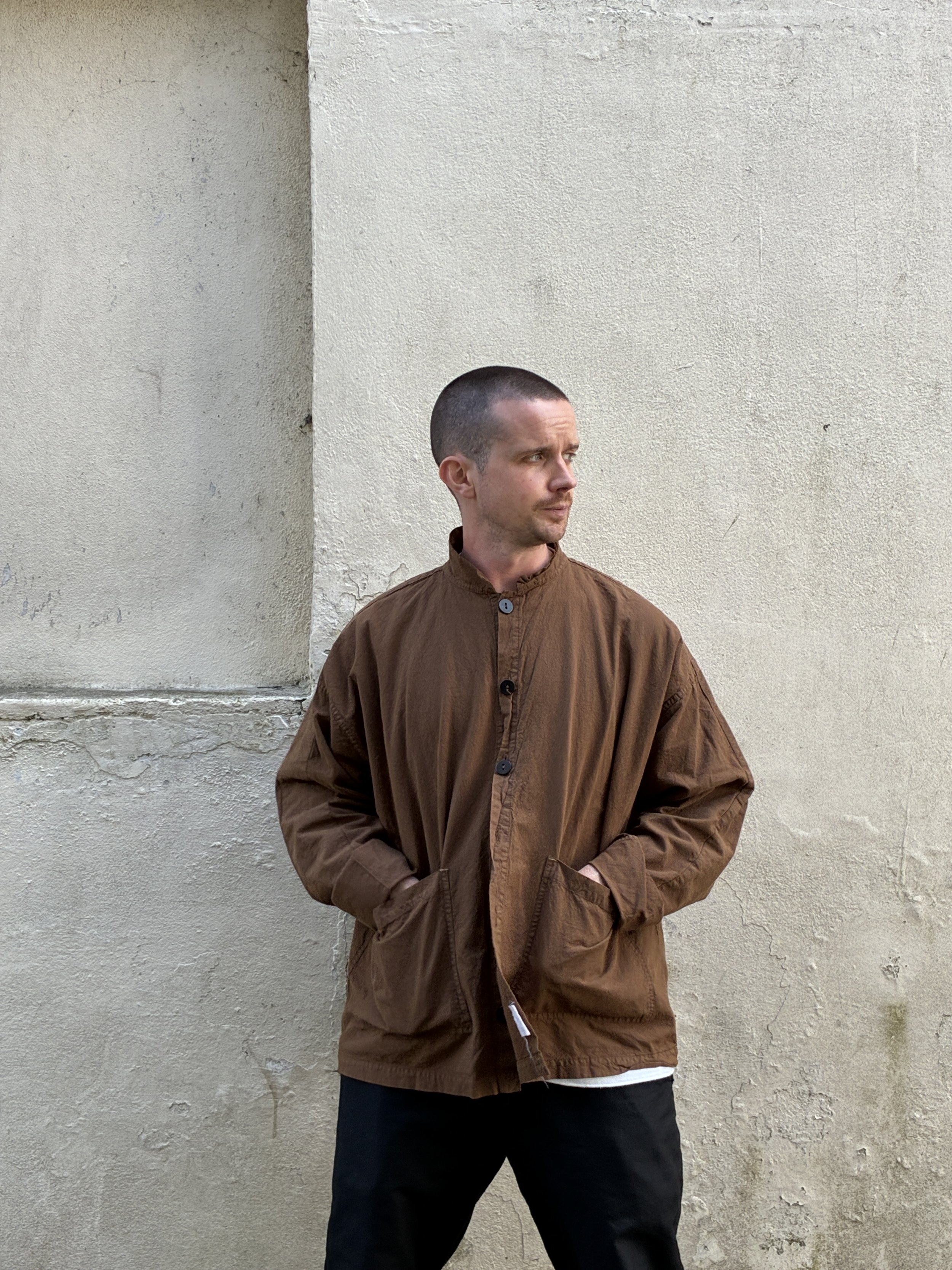 Man in front of wall wearing Tender Co Type 485 Isosceles Brown Hat Shirt