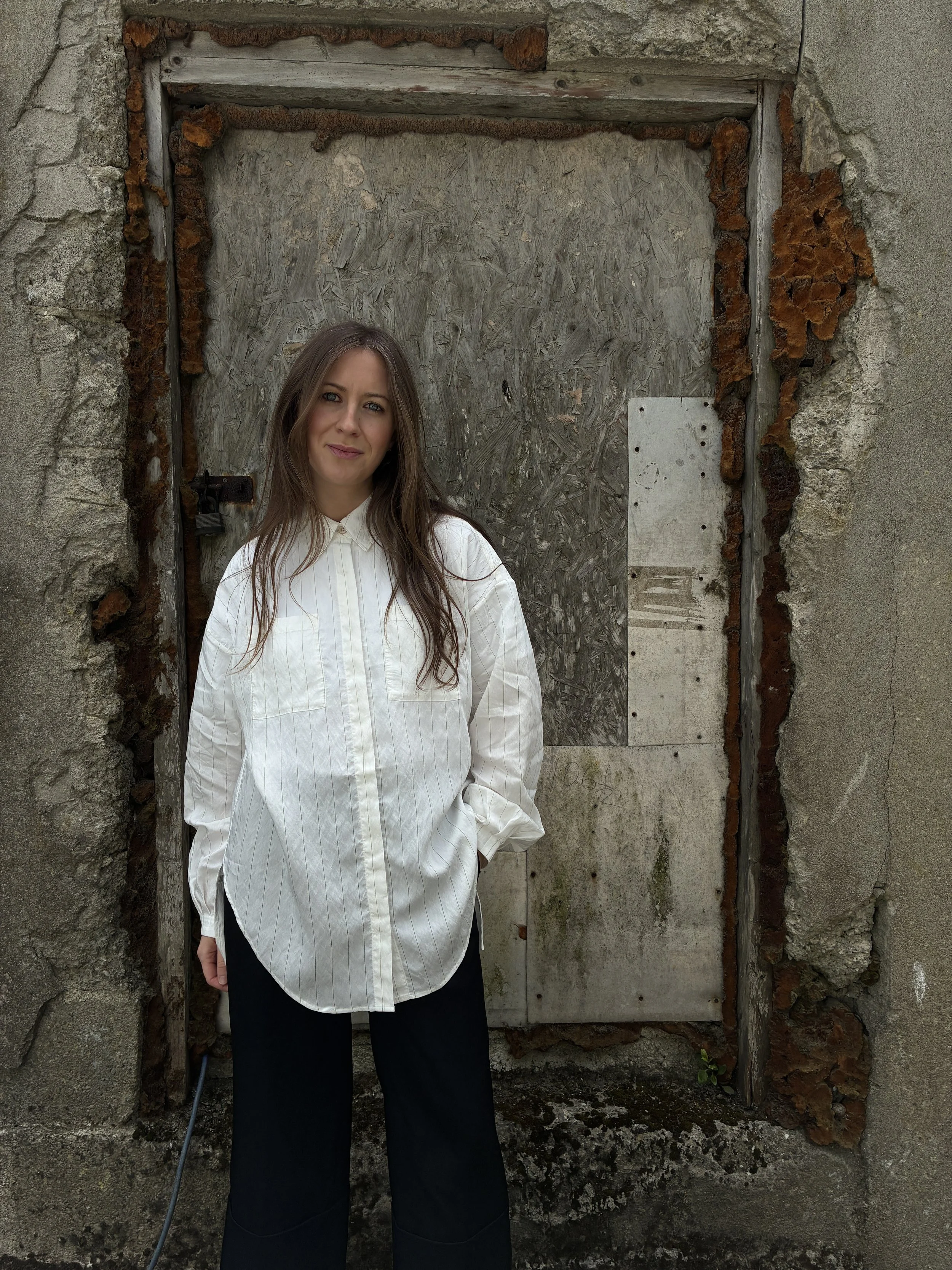 Woman in front of wall wearing 1st PAT-RN Woman Modula Shirt in  Tailored Stripes