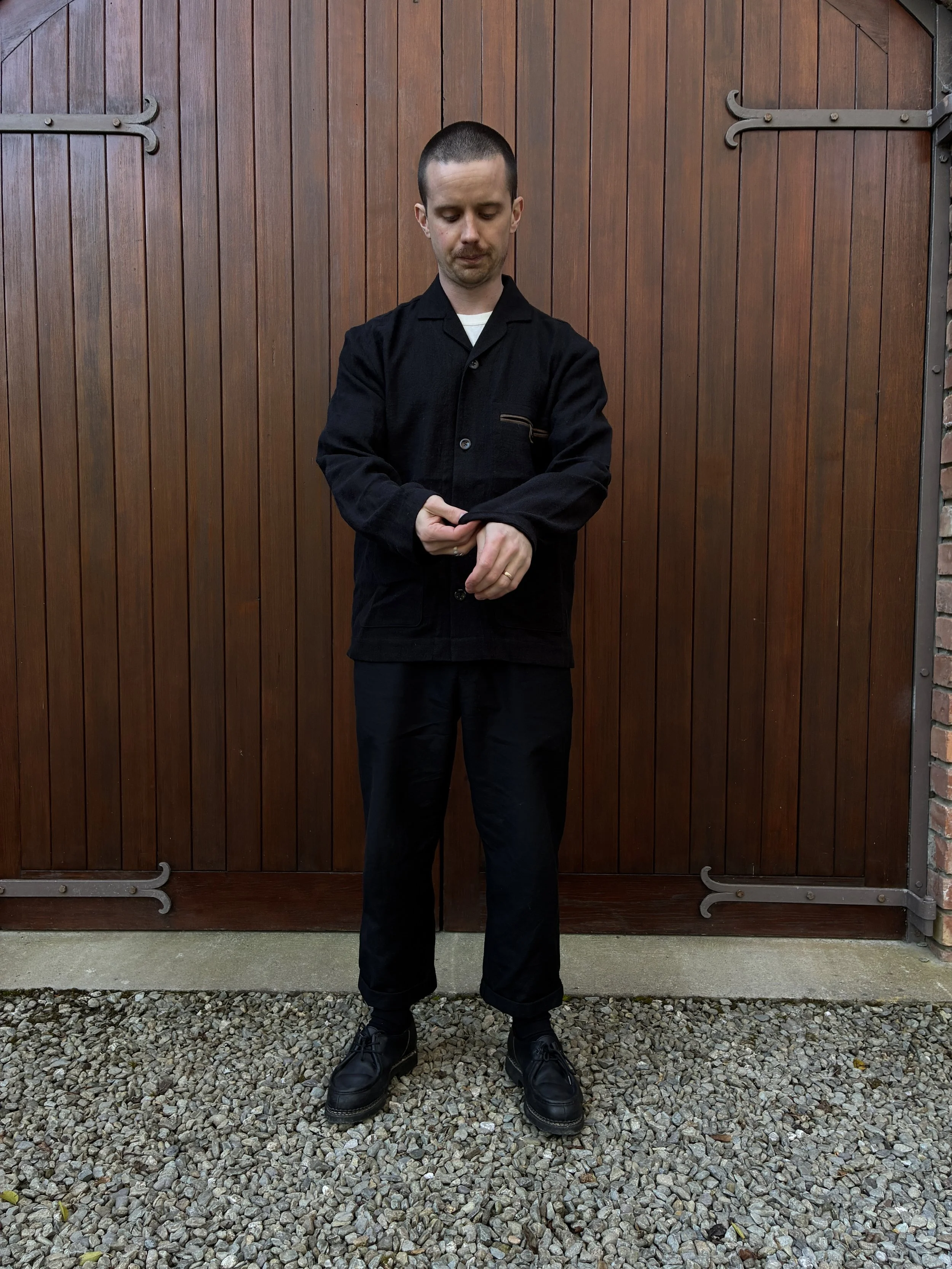 Full silhouette of man in front of door fixing sleeves of Frank Leder Black Wool Shirt Jacket
