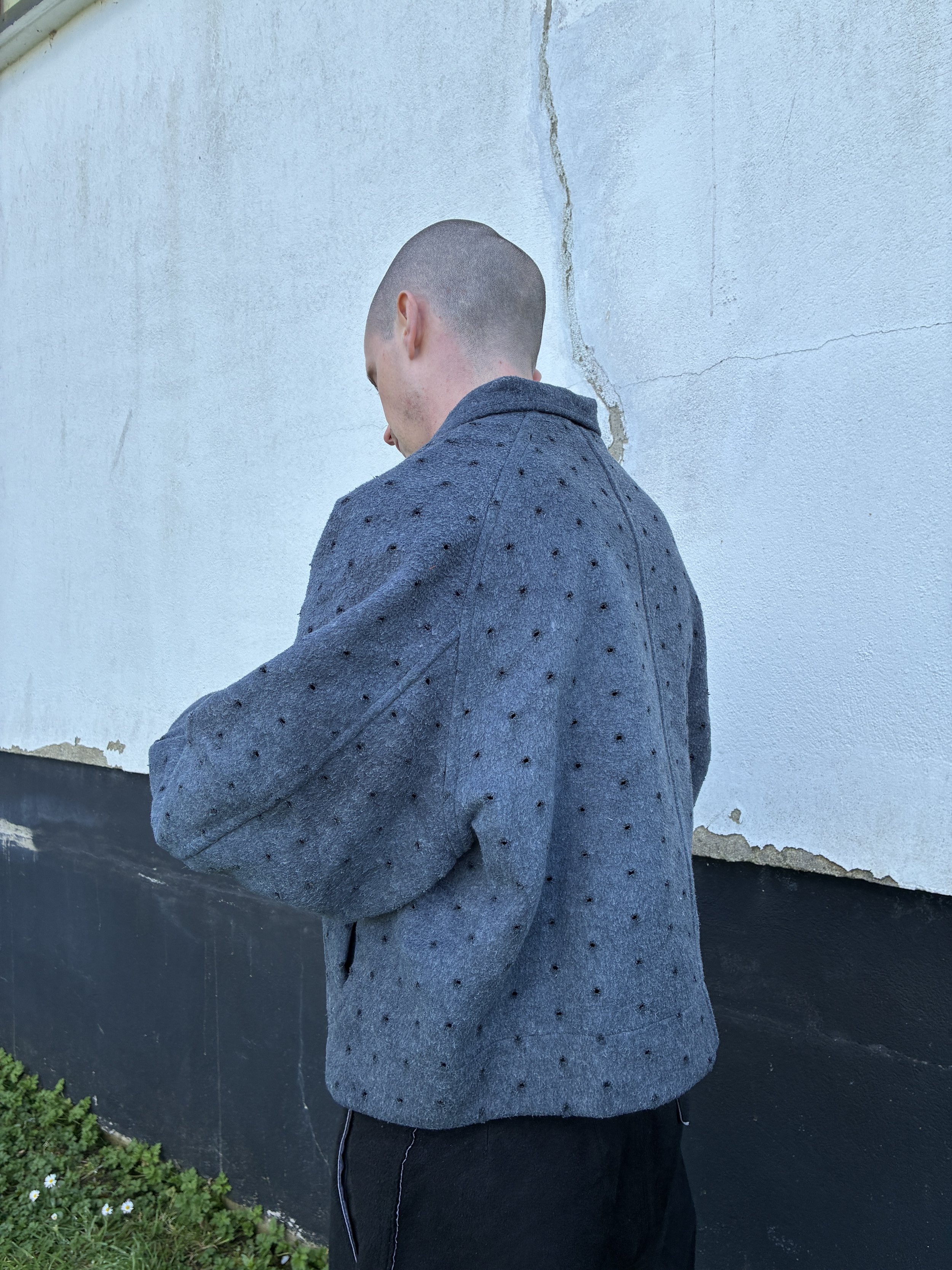 Side profile of man outside wearing Middle Distance grey Drill jacket