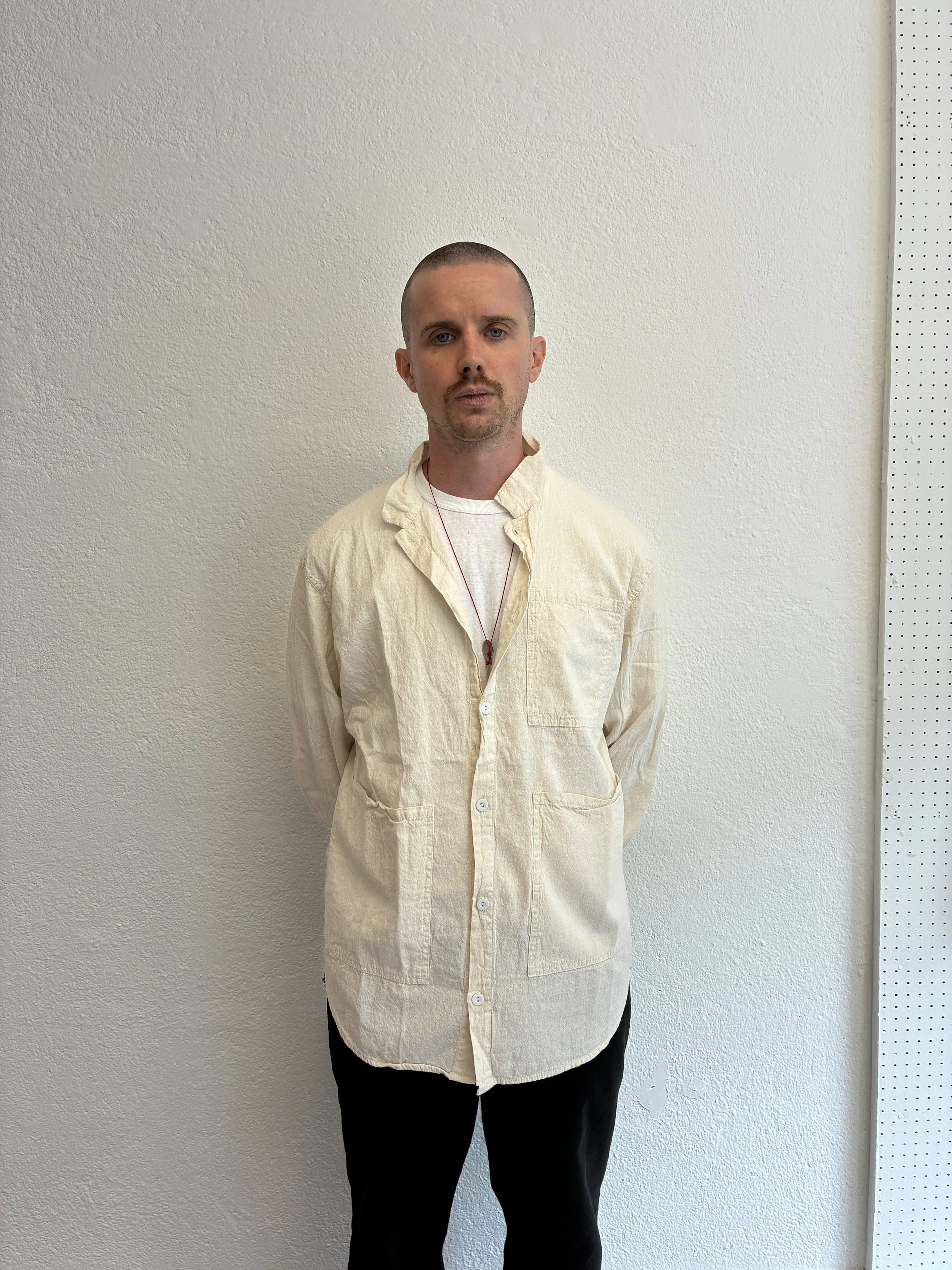 man wearing Tender Co Type 457 ecru rinsed Frock Shirt in front of white wall