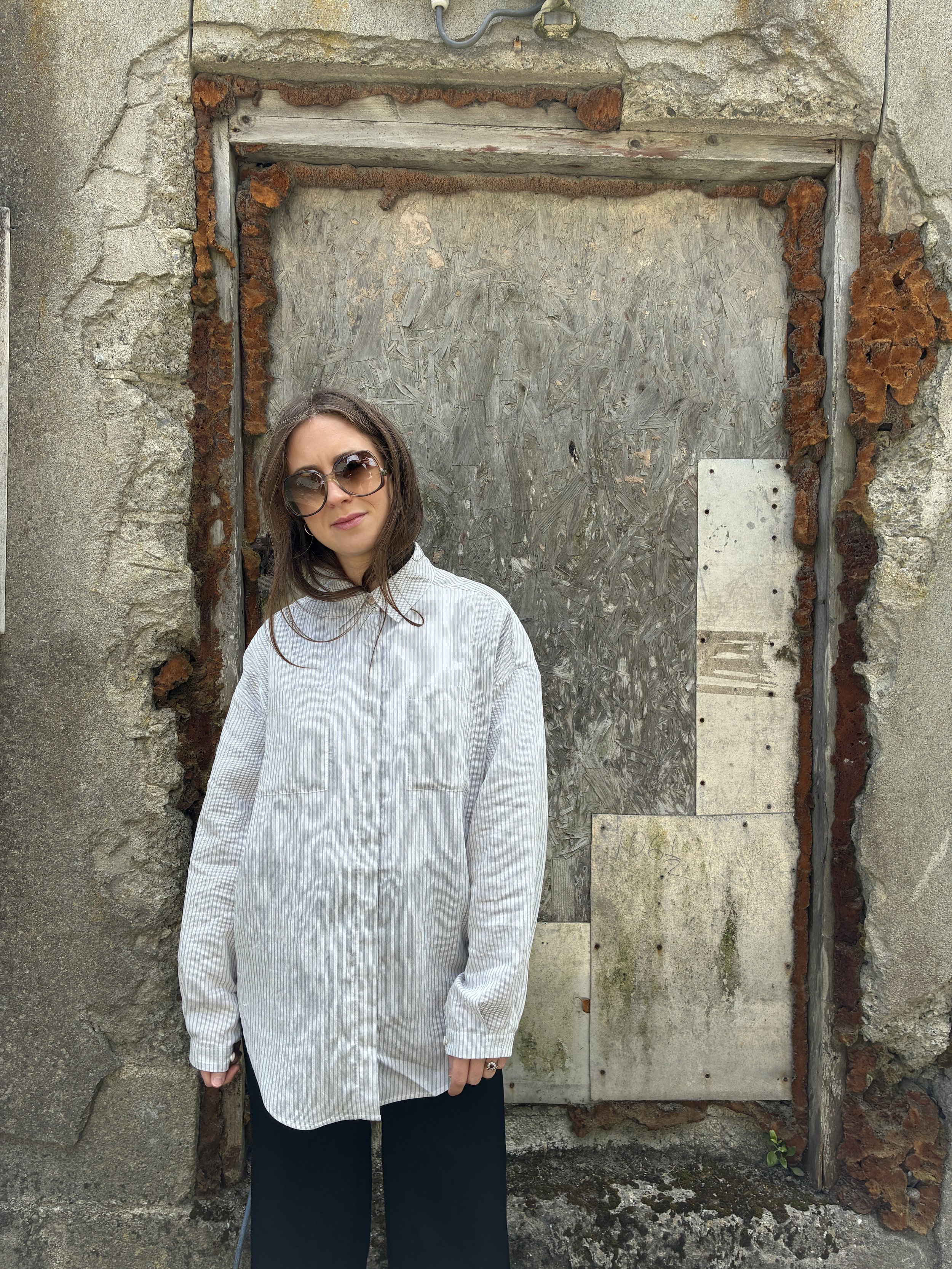 Woman in front of wall wearing 1st PAT-RN Woman Modula Shirt in Fine Stripes
