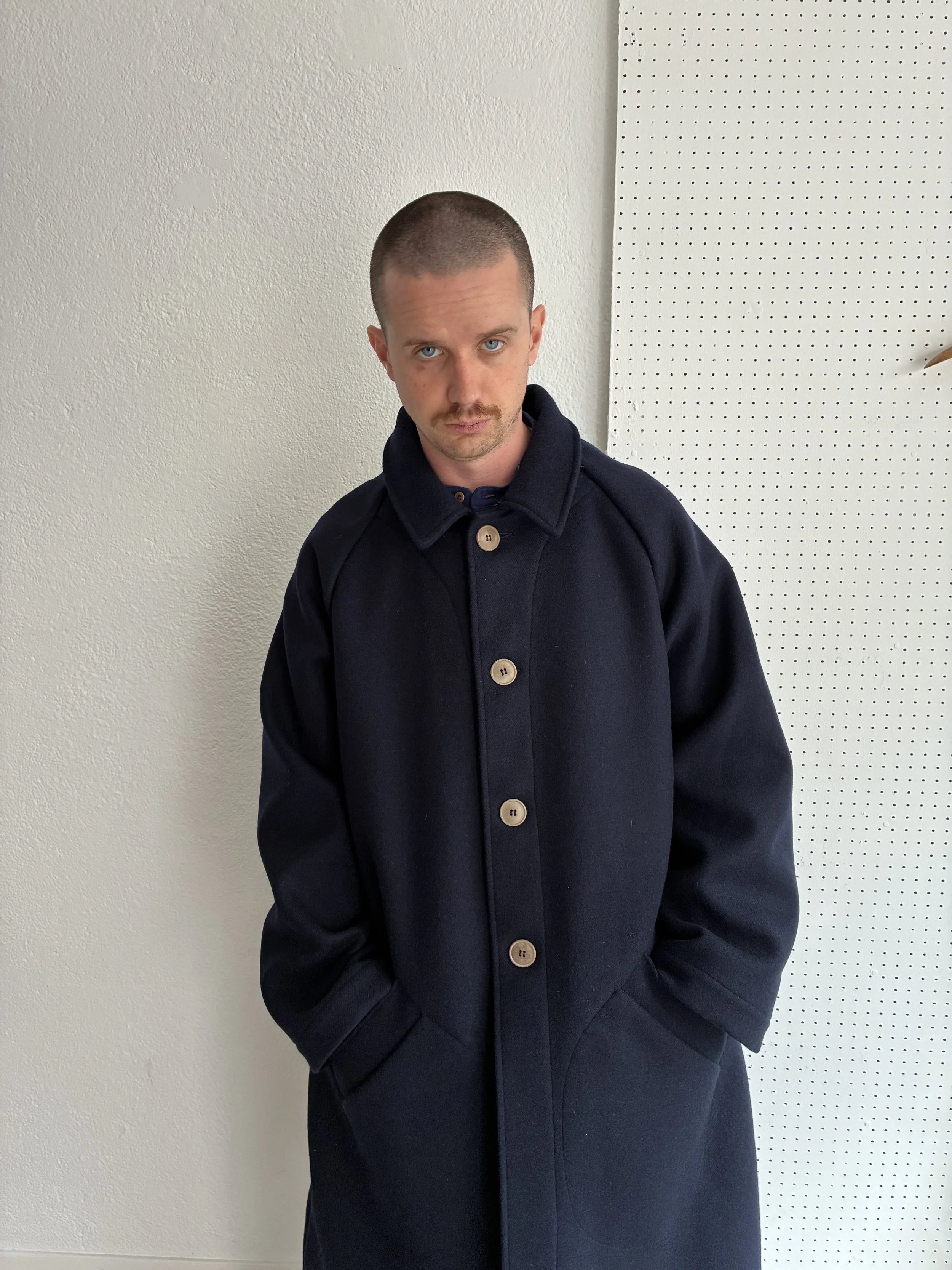 Model wears Frank Leder Navy Wool Duster Coat, front profile view
