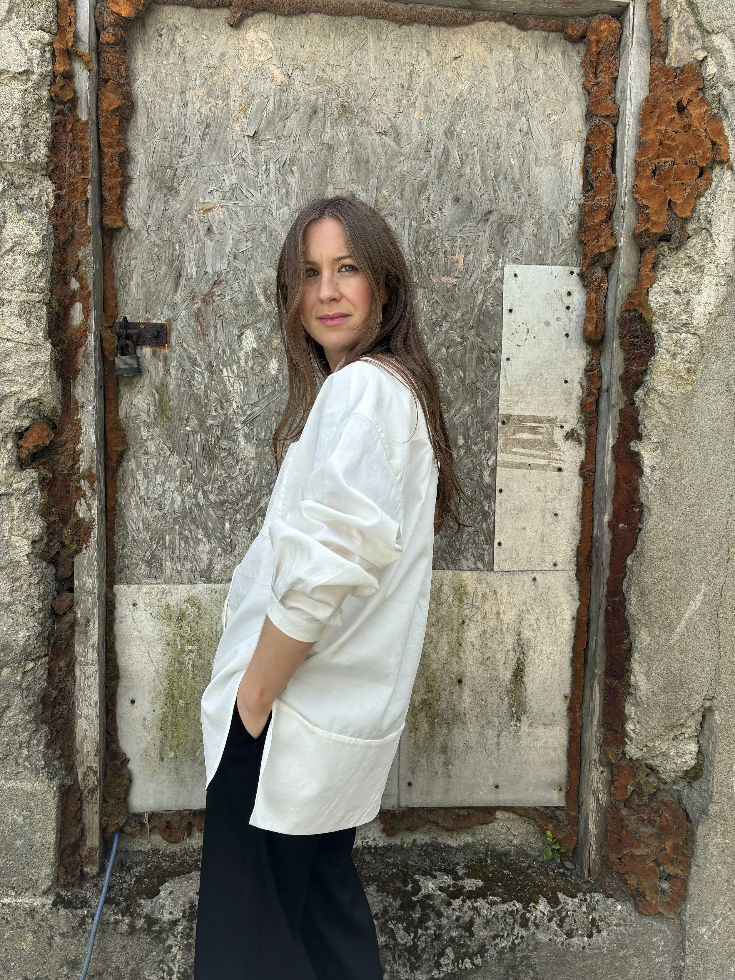 Side of woman Woman in front of wall wearing White 1st PAT-RN Woman Modula Shirt