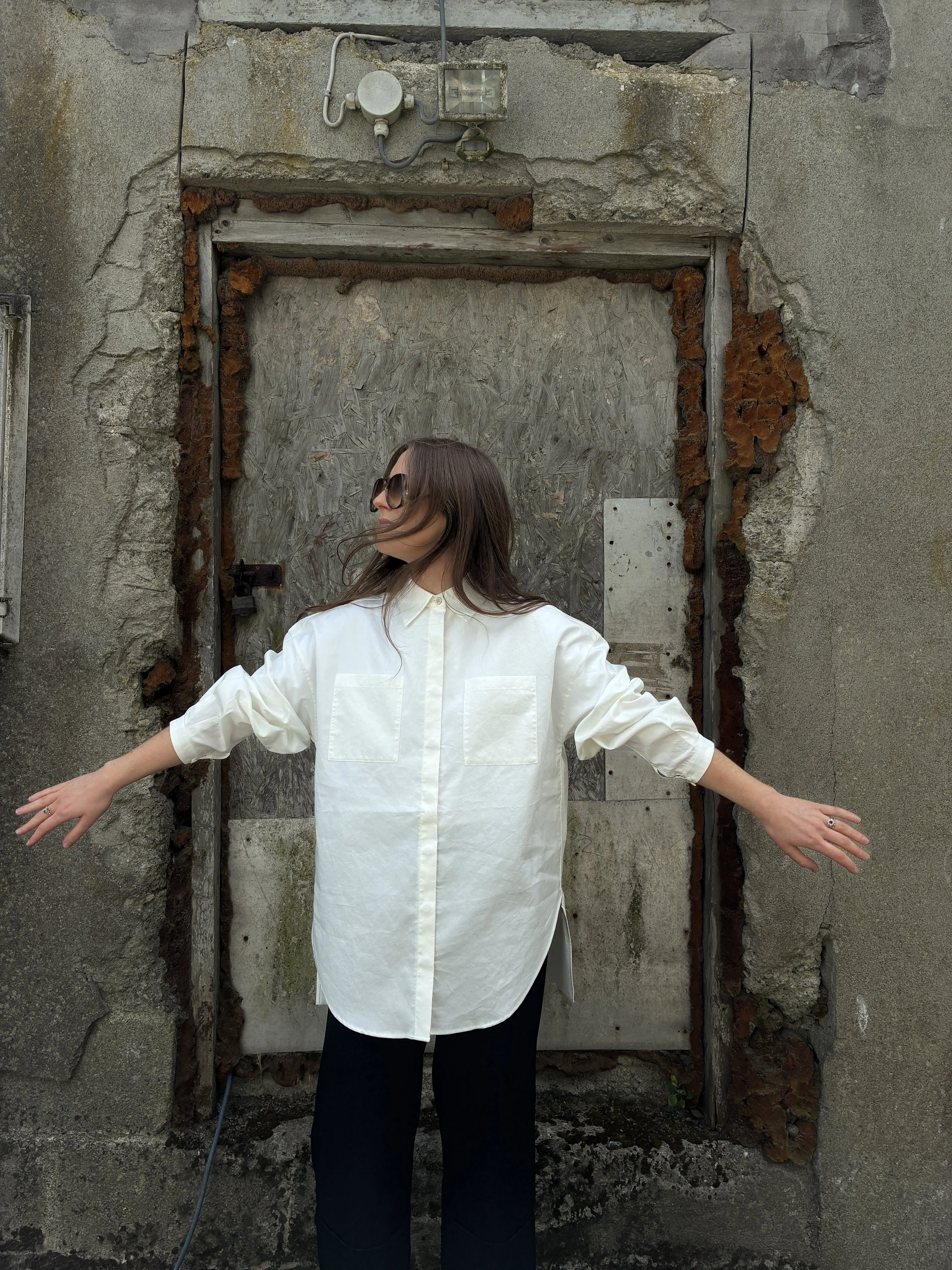 Woman posing in front of wall wearing White 1st PAT-RN Woman Modula Shirt