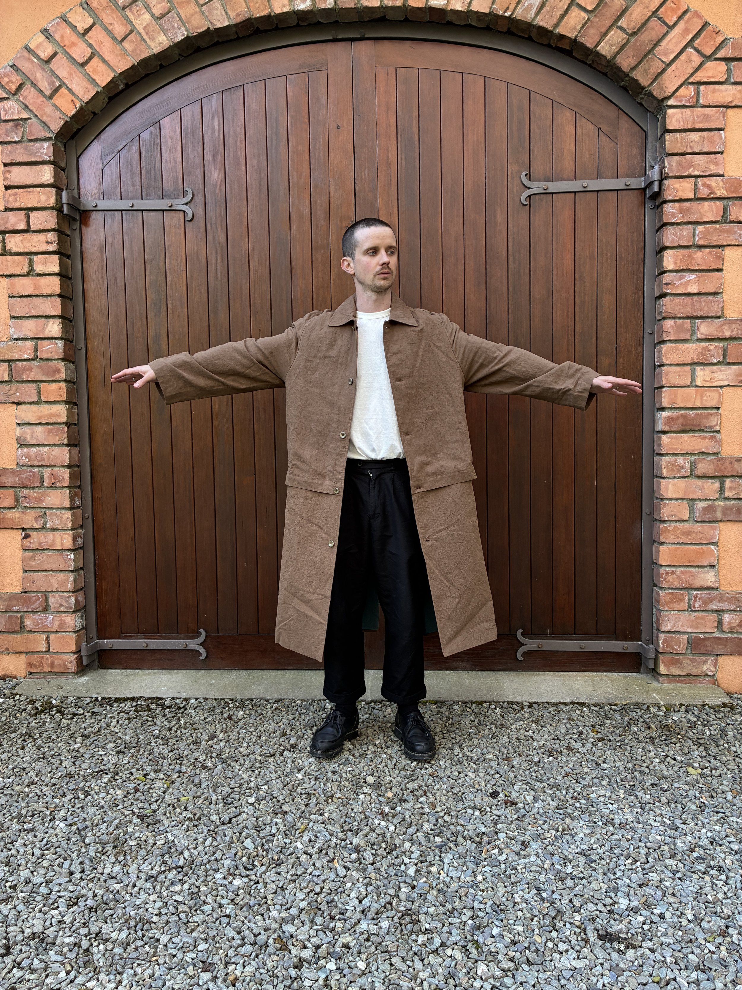 Man in front of door modelling Frank Leder Reversible Coat in Brown and Teal