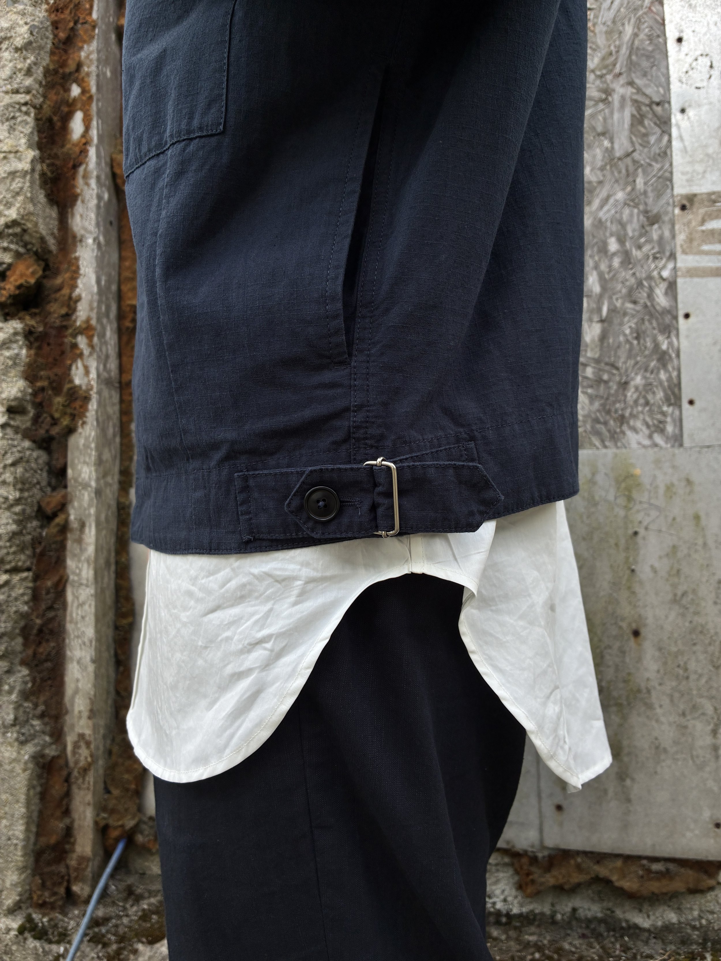 Closeup of hem of 1st PAT-RN Navy Camden Jacket worn over shirt