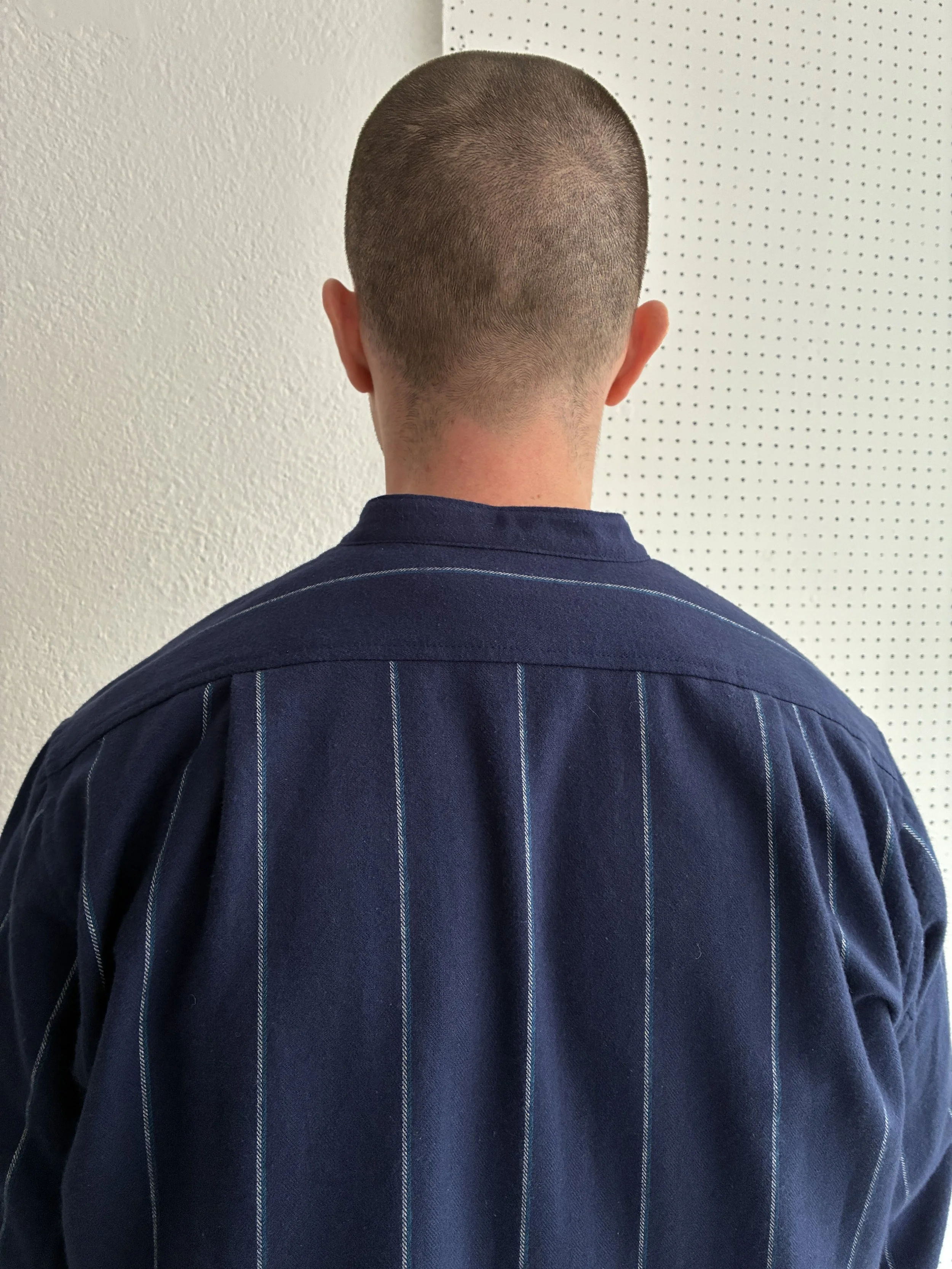 Model wears a Frank Leder navy striped shirt, closeup view of back.