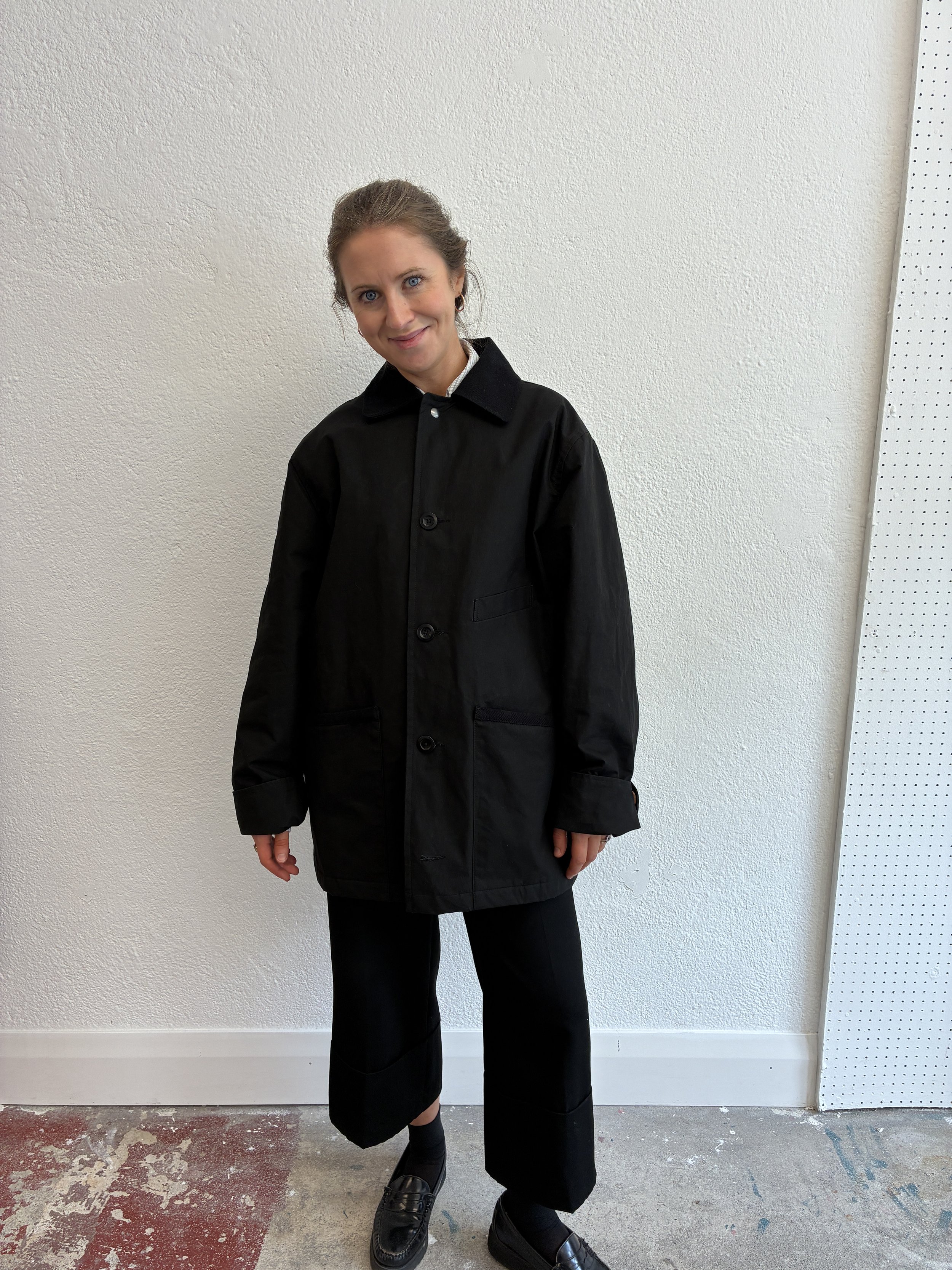 Woman wearing Black Conkers Blanket Jacket in front of white wall