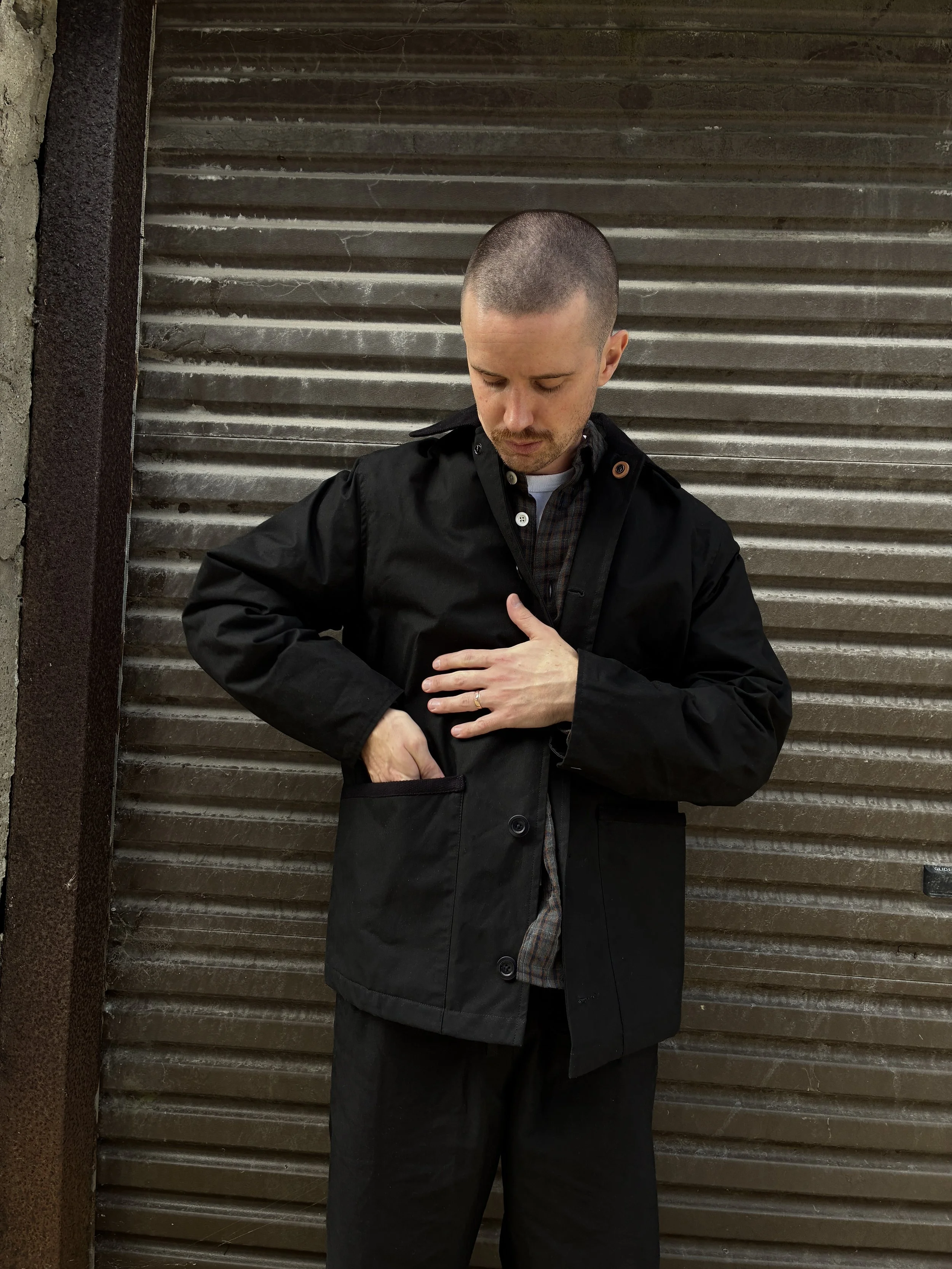 Man wearing Black Conkers Blanket Jacket in front of shutters