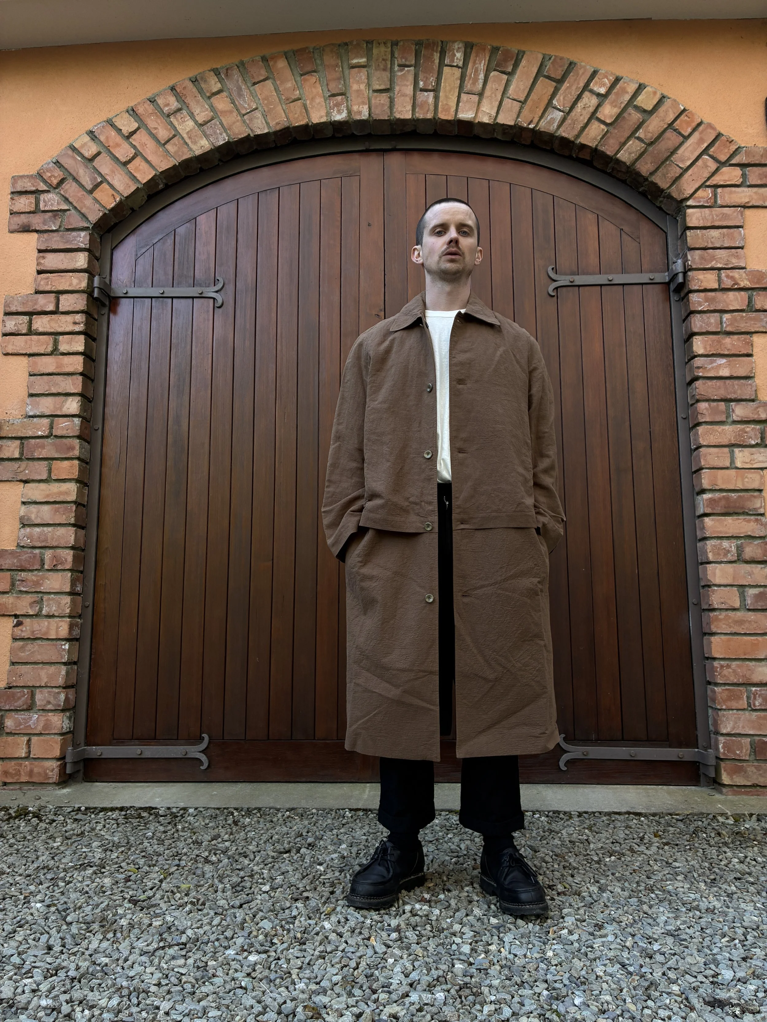 Man in front of door wearing Frank Leder Reversible Coat in Brown
