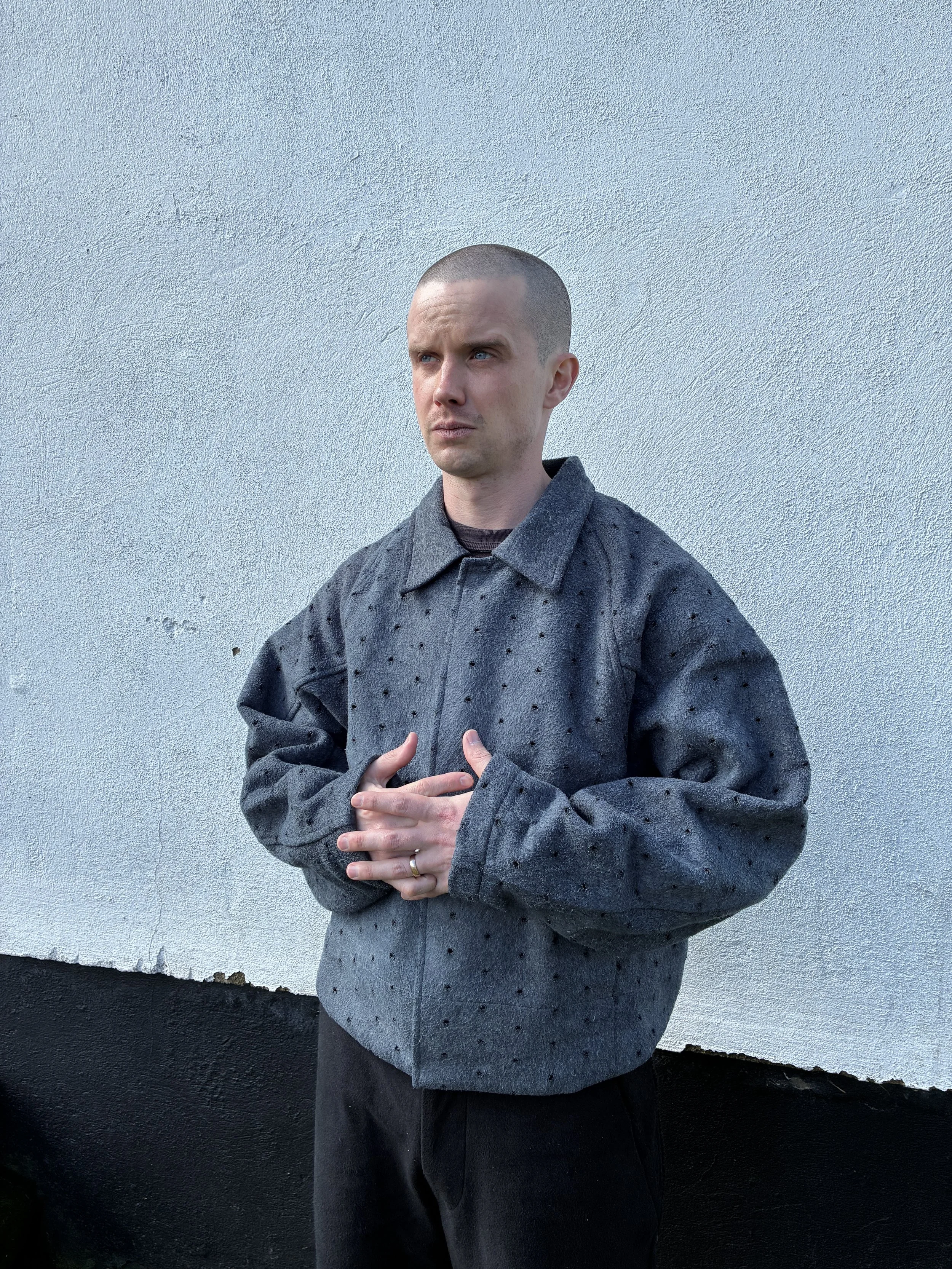 Man outside wearing Middle Distance grey Drill jacket with hands crossed