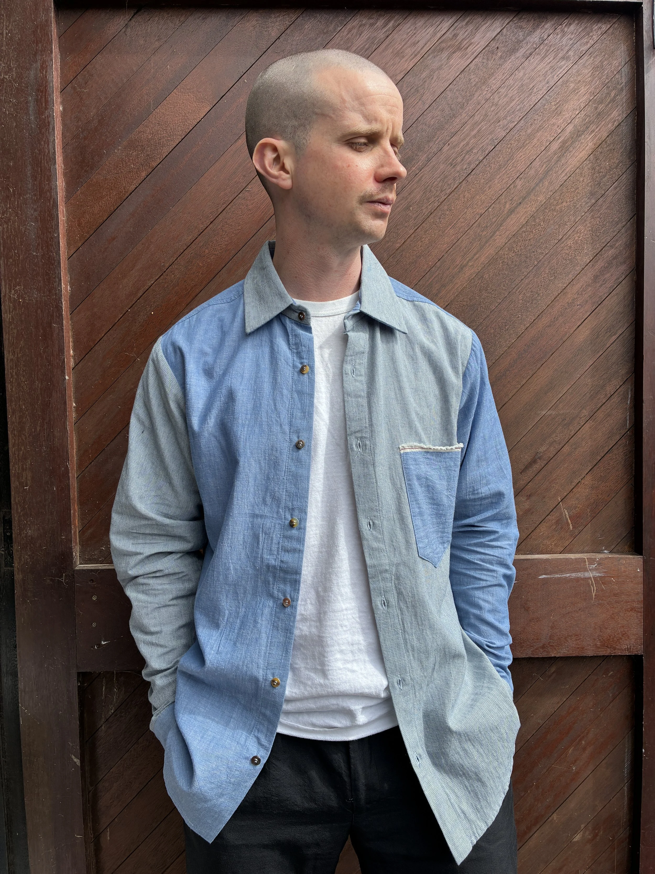 Man in front of door wearing Frank Leder Blue Patchwork Vintage Fabric Edition Shirt over white tshirt