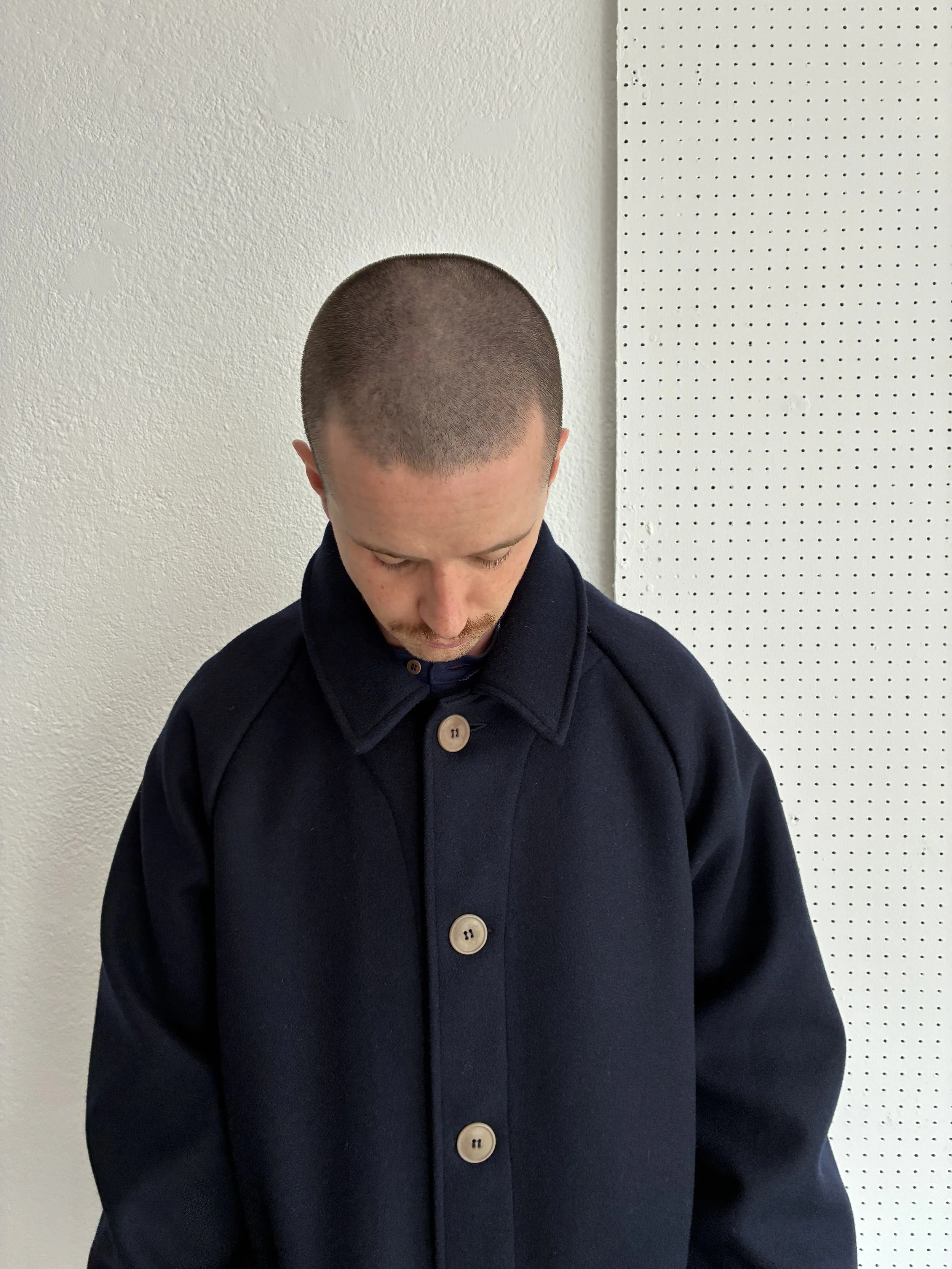 Model wears Frank Leder Navy Wool Duster Coat, front profile view