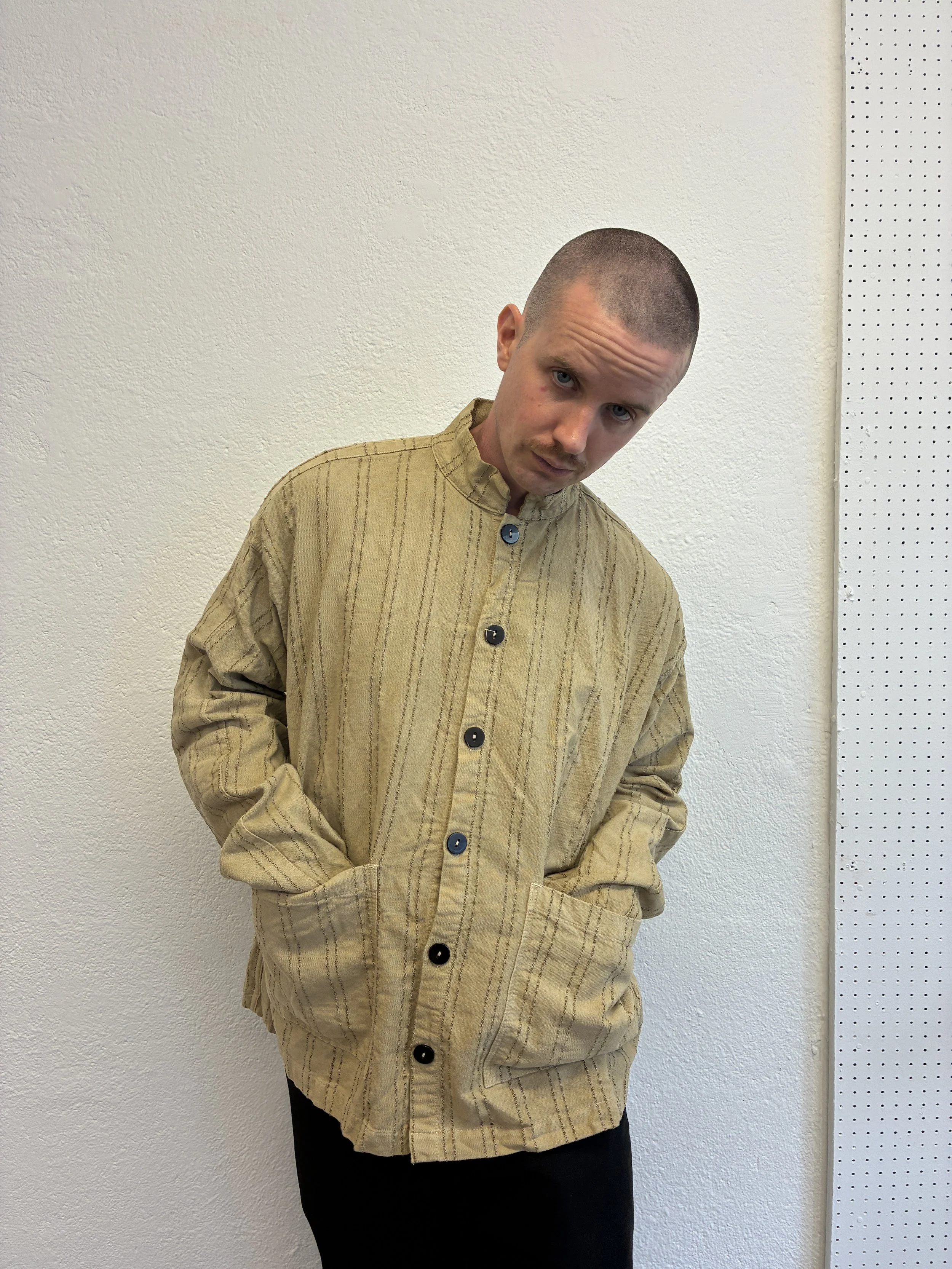 Man posing in Drab Weld Tender Co Type 485 Isosceles Shirt in front of white wall