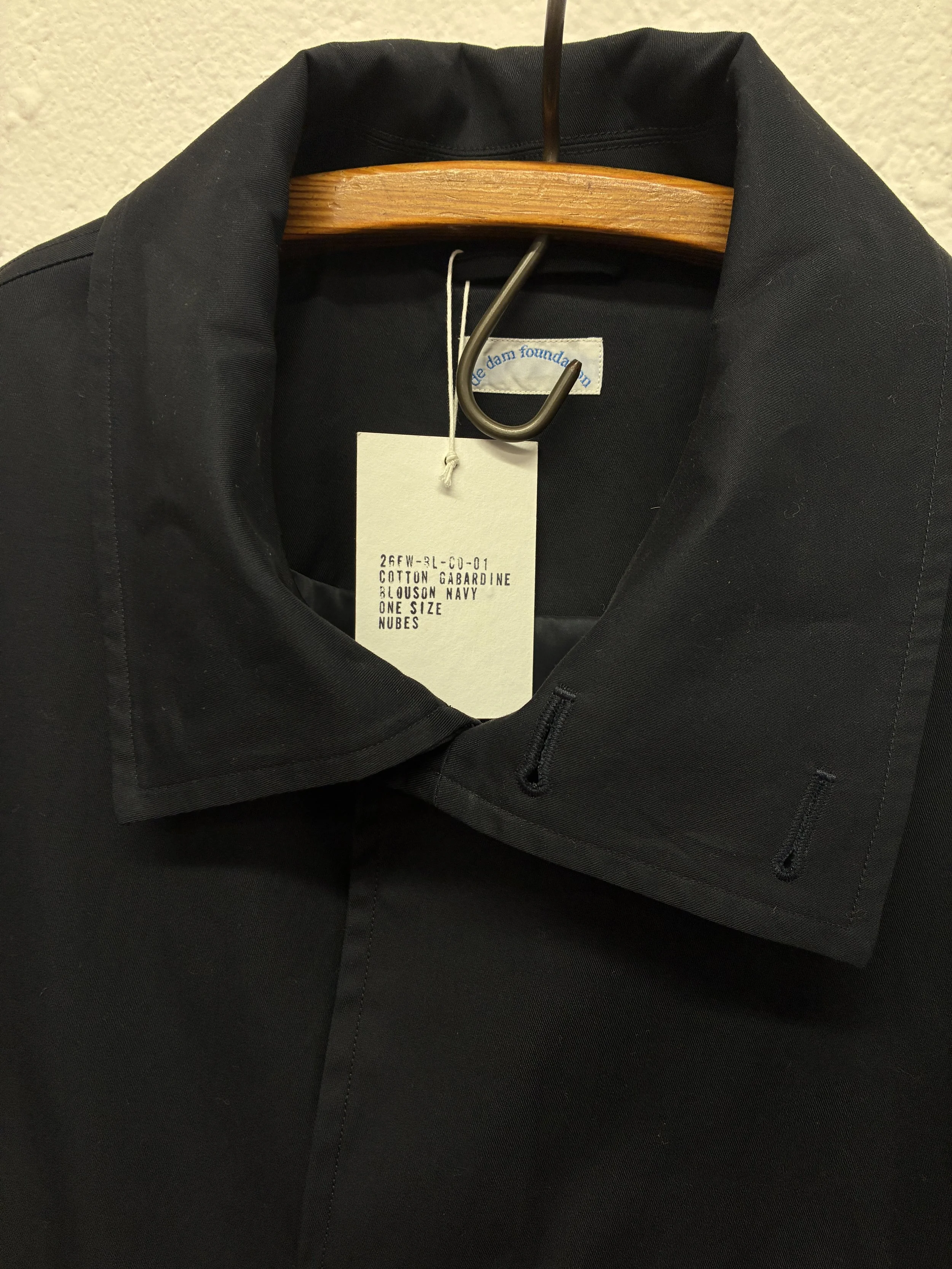 Closeup of collar of Navy De Dam Foundation Cotton Gabardine Jacket on hanger