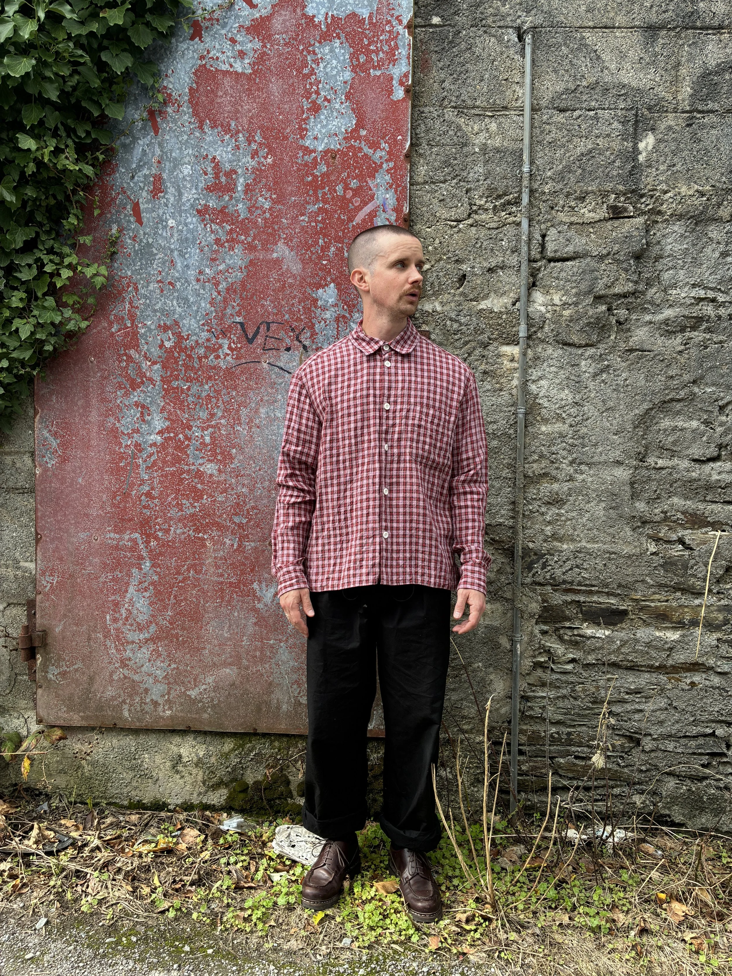 Man wearing Conkers Sunrise Relaxed Farmer Shirt in front of red wall