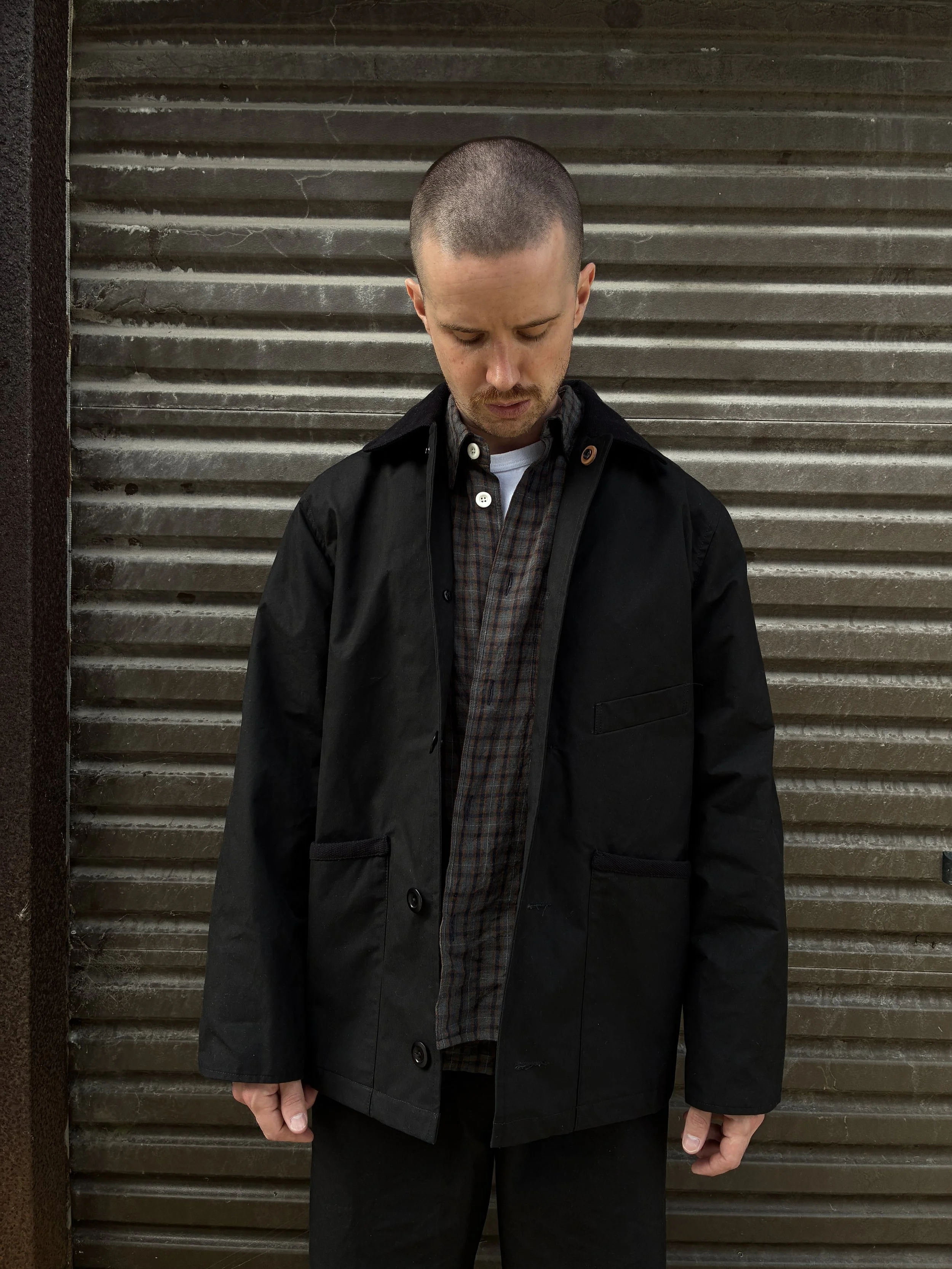 Man wearing Black Conkers Blanket Jacket in front of shutters