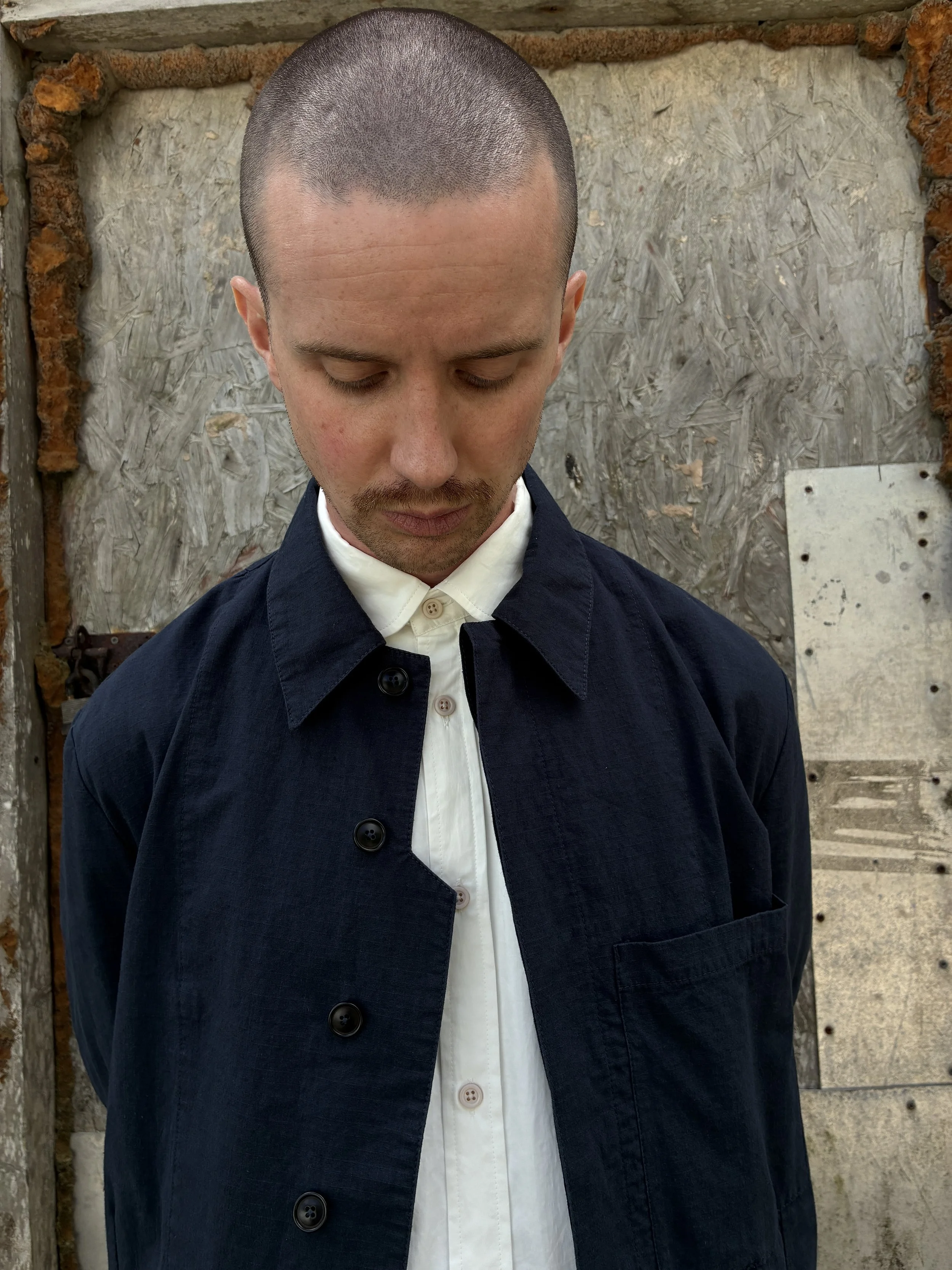Closeup of Man in front of wall wearing 1st PAT-RN Navy Camden Jacket