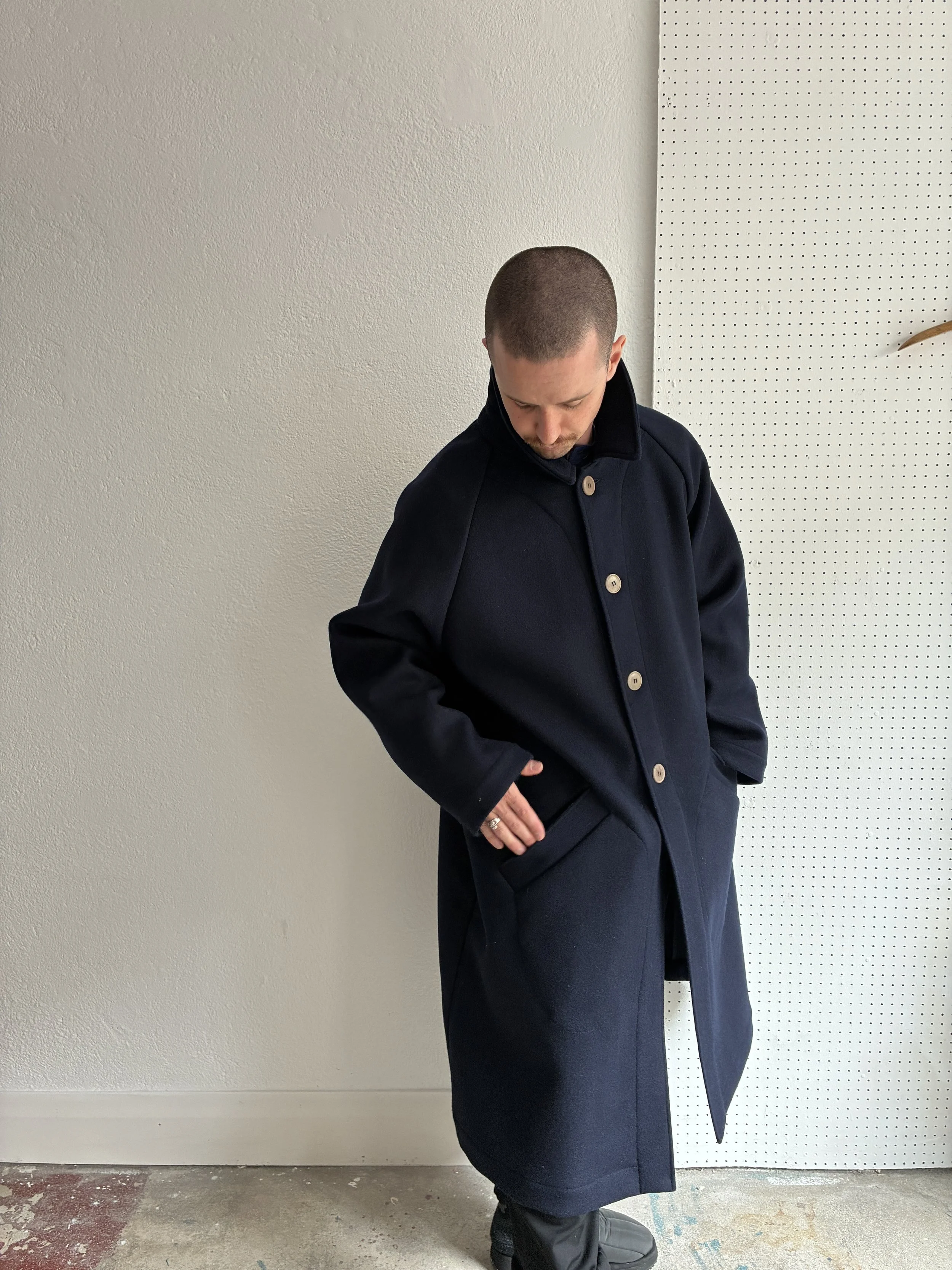 Model wears Frank Leder Navy Wool Duster Coat, side profile view