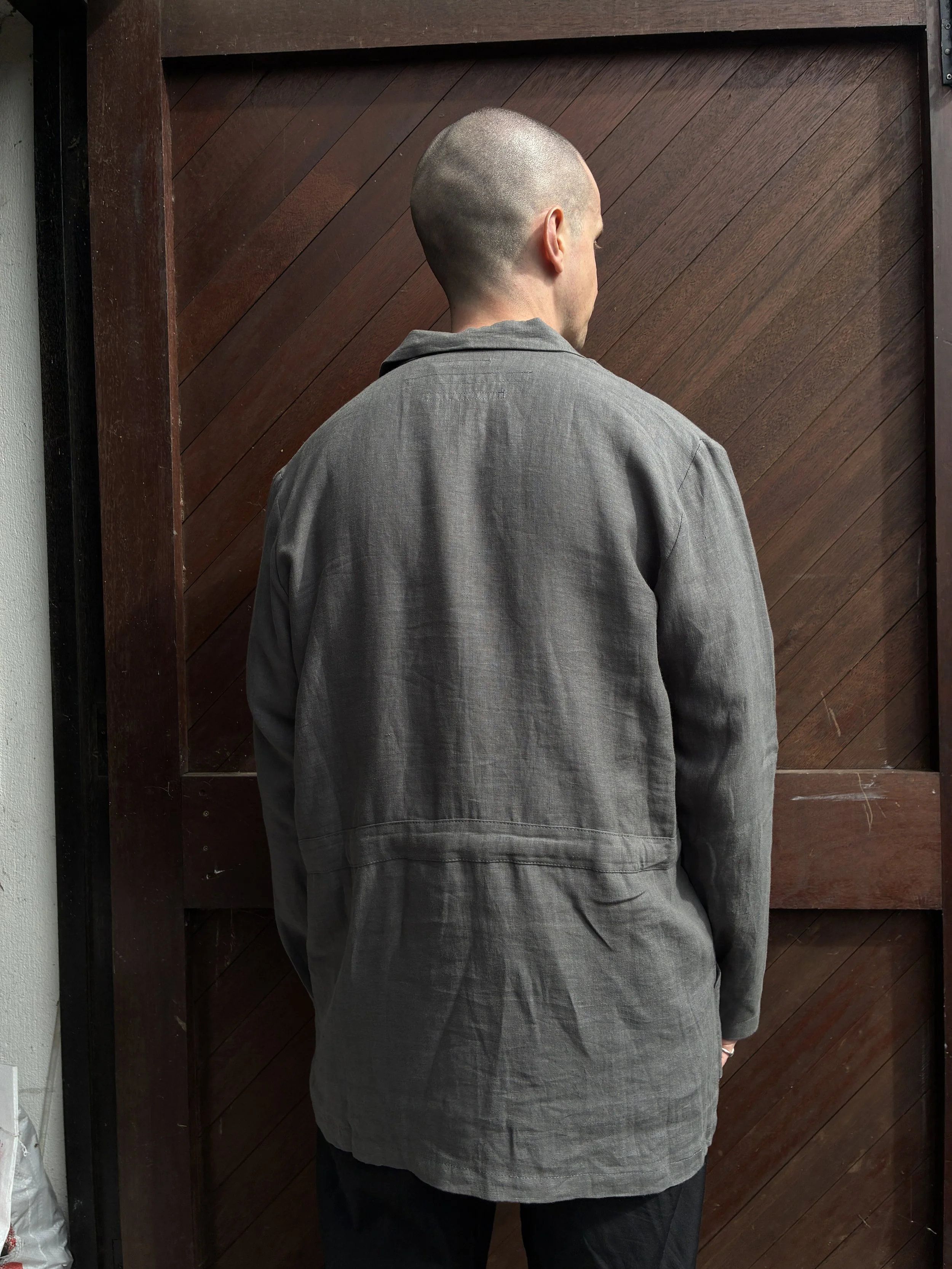 Back of man in front of wooden door wearing Limited Edition Frank Leder Grey LINDWURM Linen Cardigan