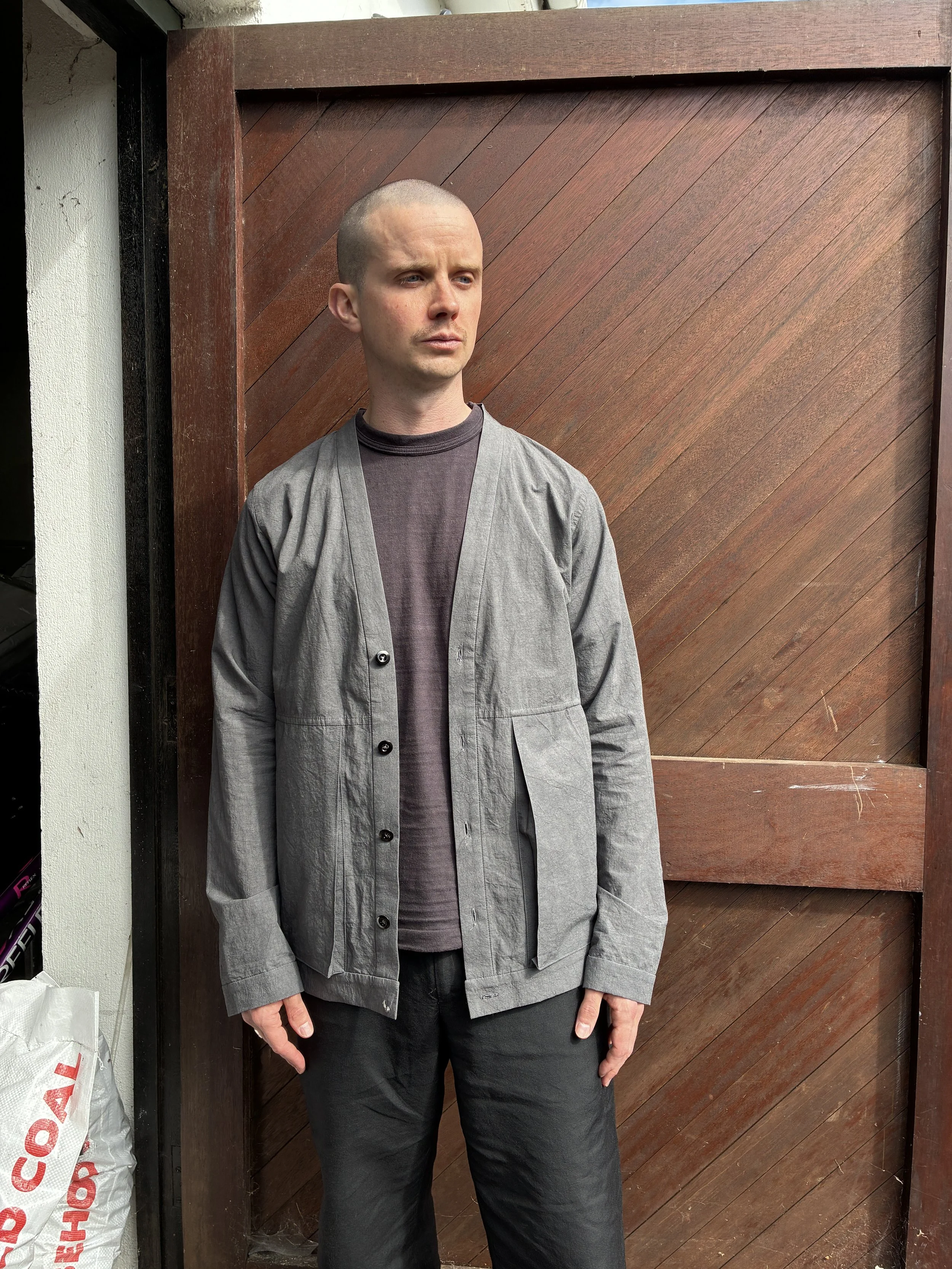 Man in front of wooden door wearing Frank Leder Grey Japanese Cotton Cardigan
