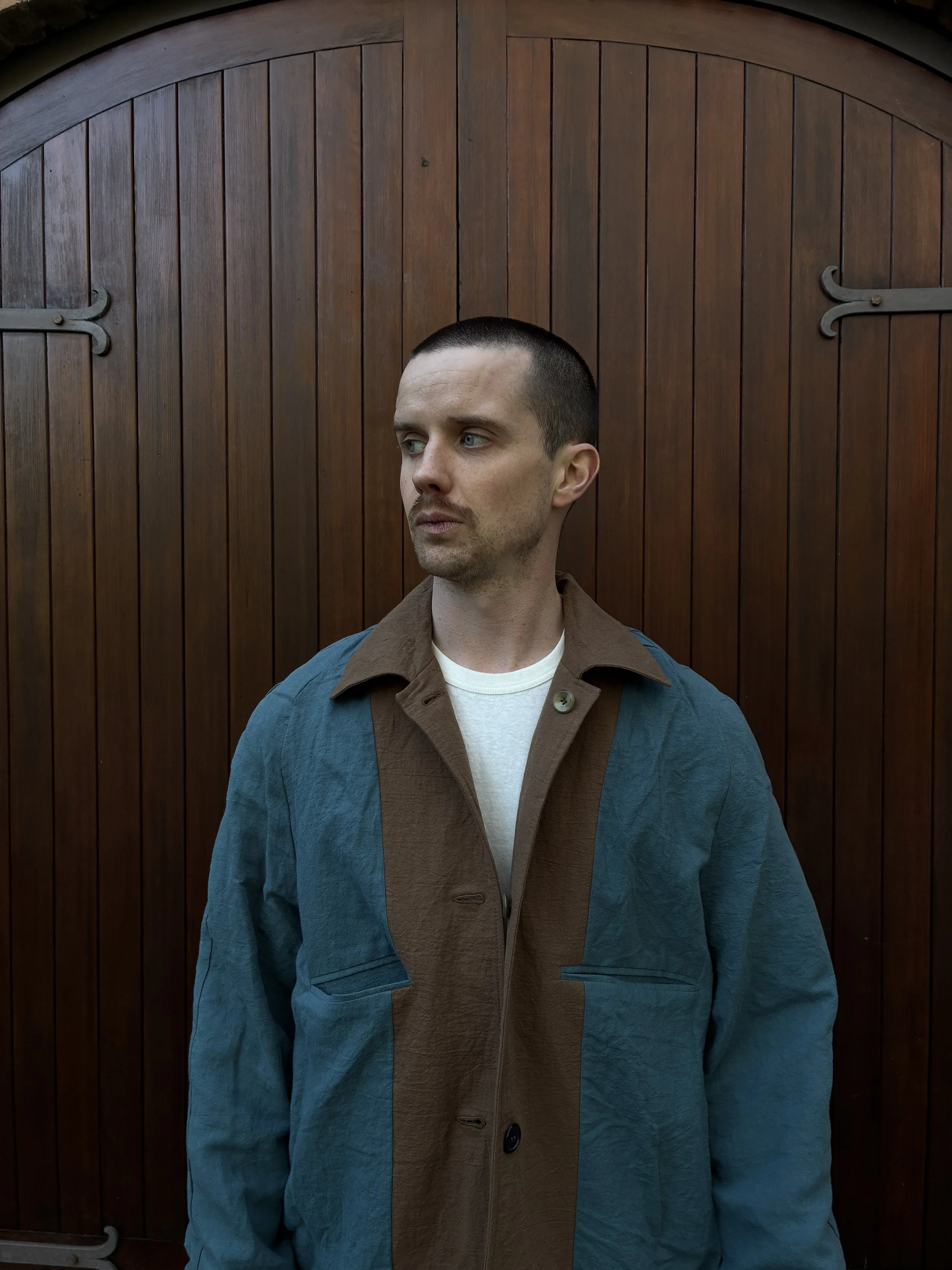Closeup of Man in front of door wearing Frank Leder Reversible Coat Teal