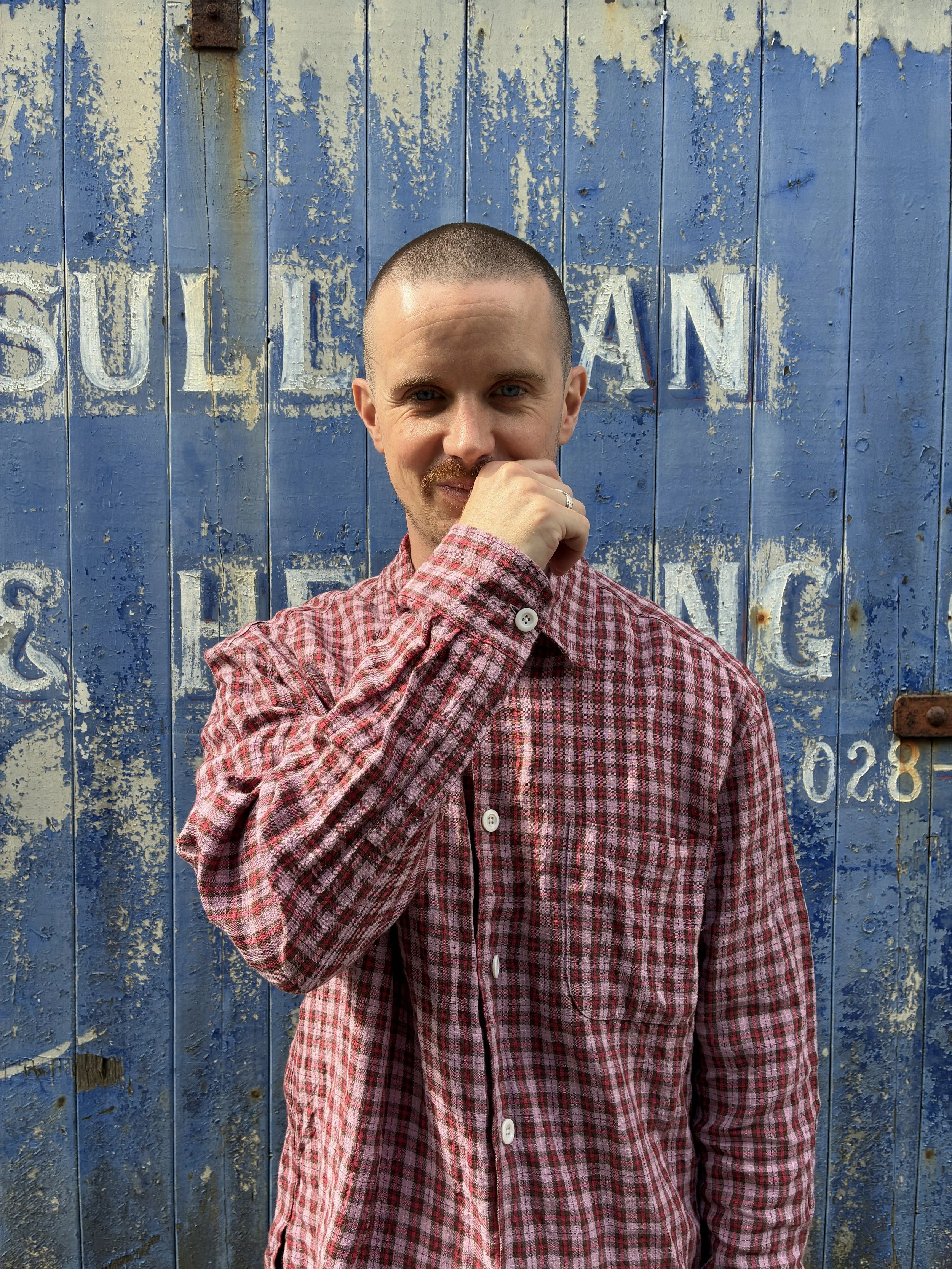 Closeup of Man wearing Conkers Sunrise Relaxed Farmer Shirt in front of blue shutter