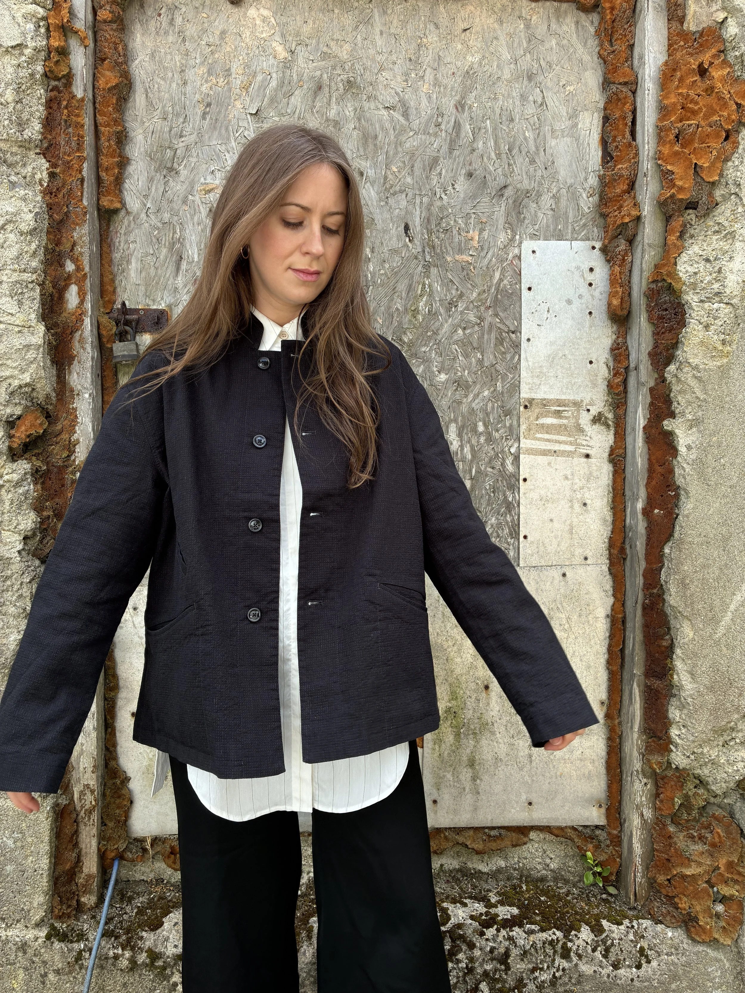Woman in front of wall wearing Charcoal 1st PAT-RN Woman Rei Jacket