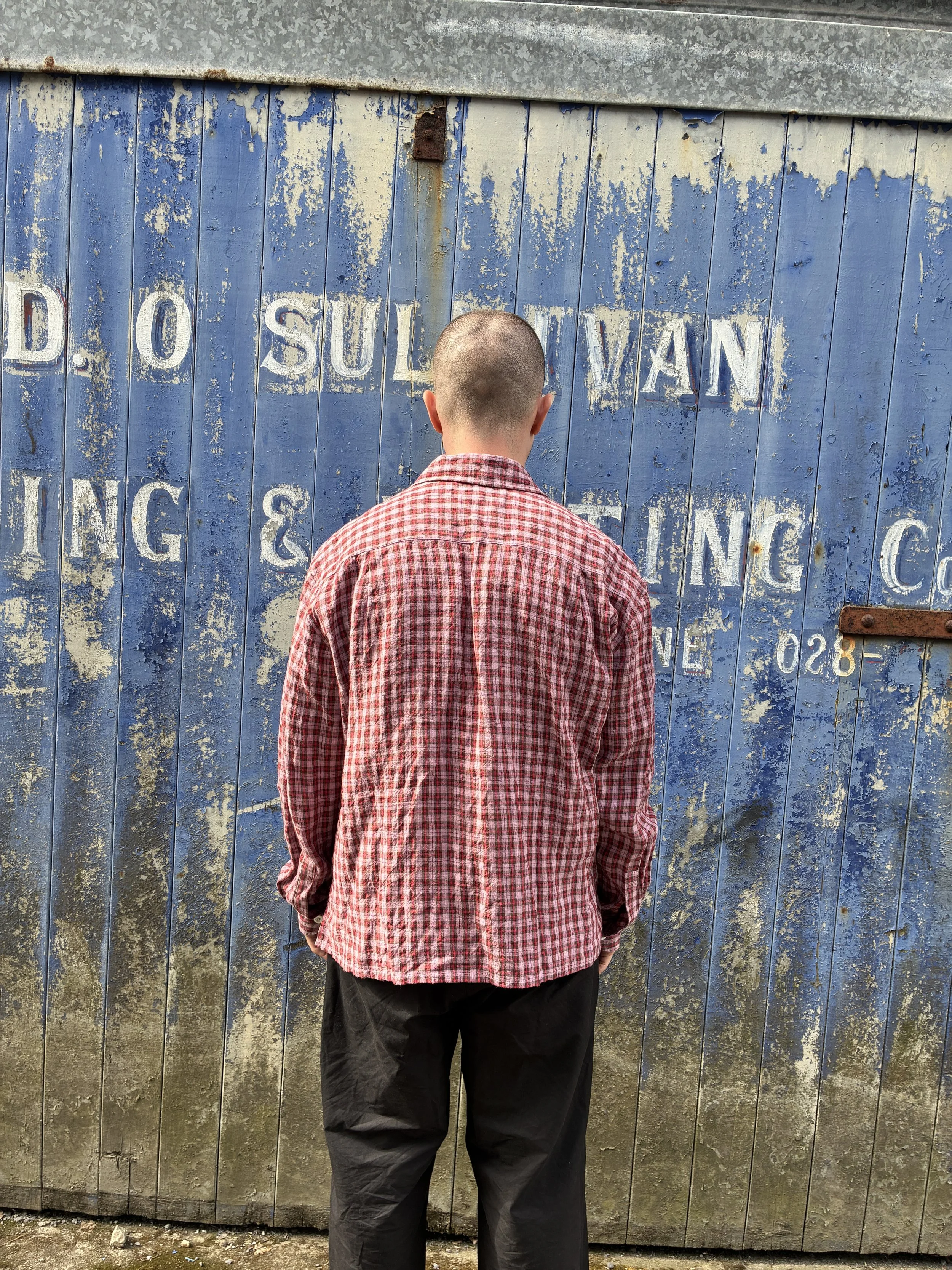 Back of Man wearing Conkers Sunrise Relaxed Farmer Shirt in front of blue shutter