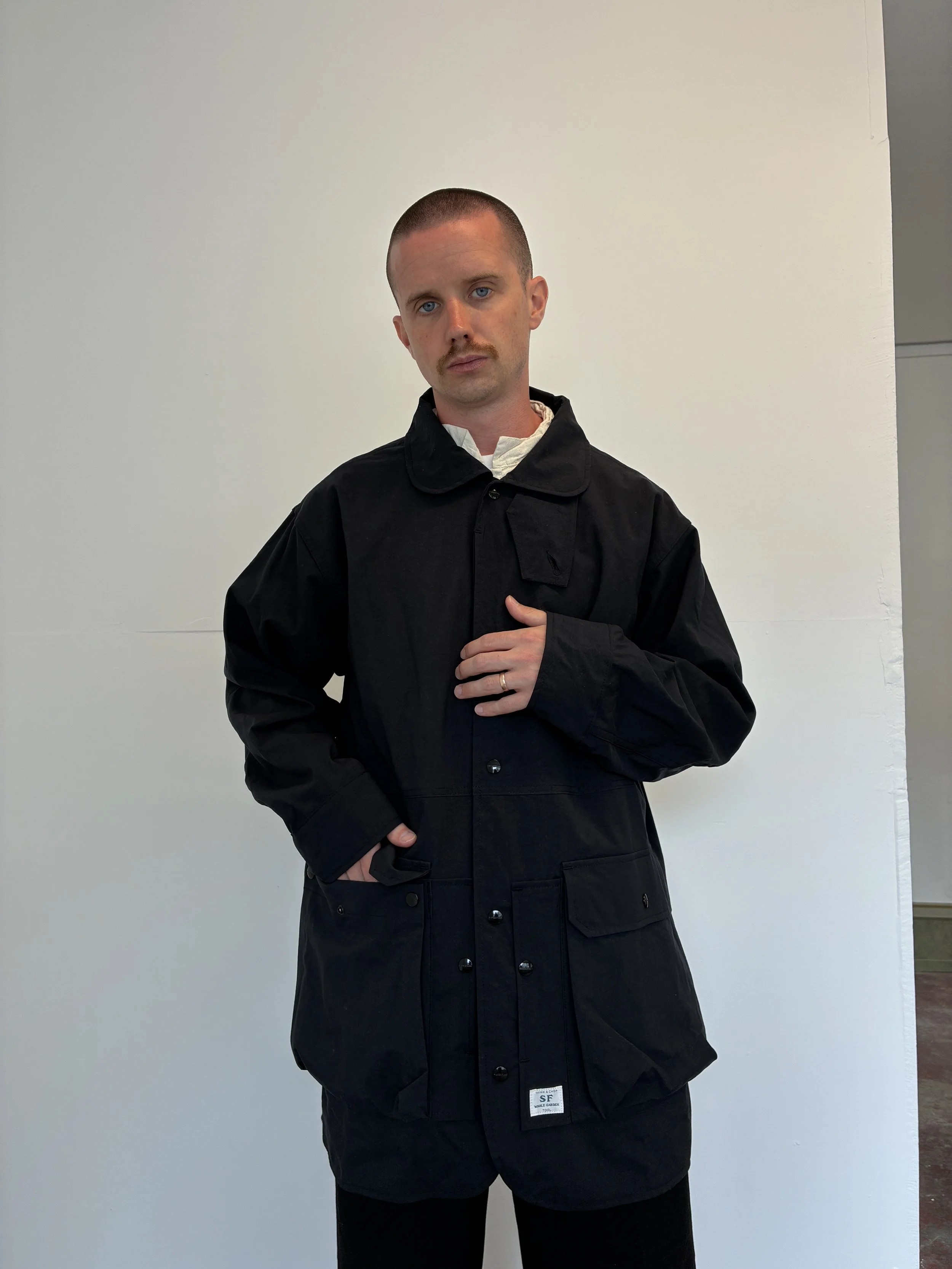 Man posing while wearing Black Sassafras Cultivator Coat