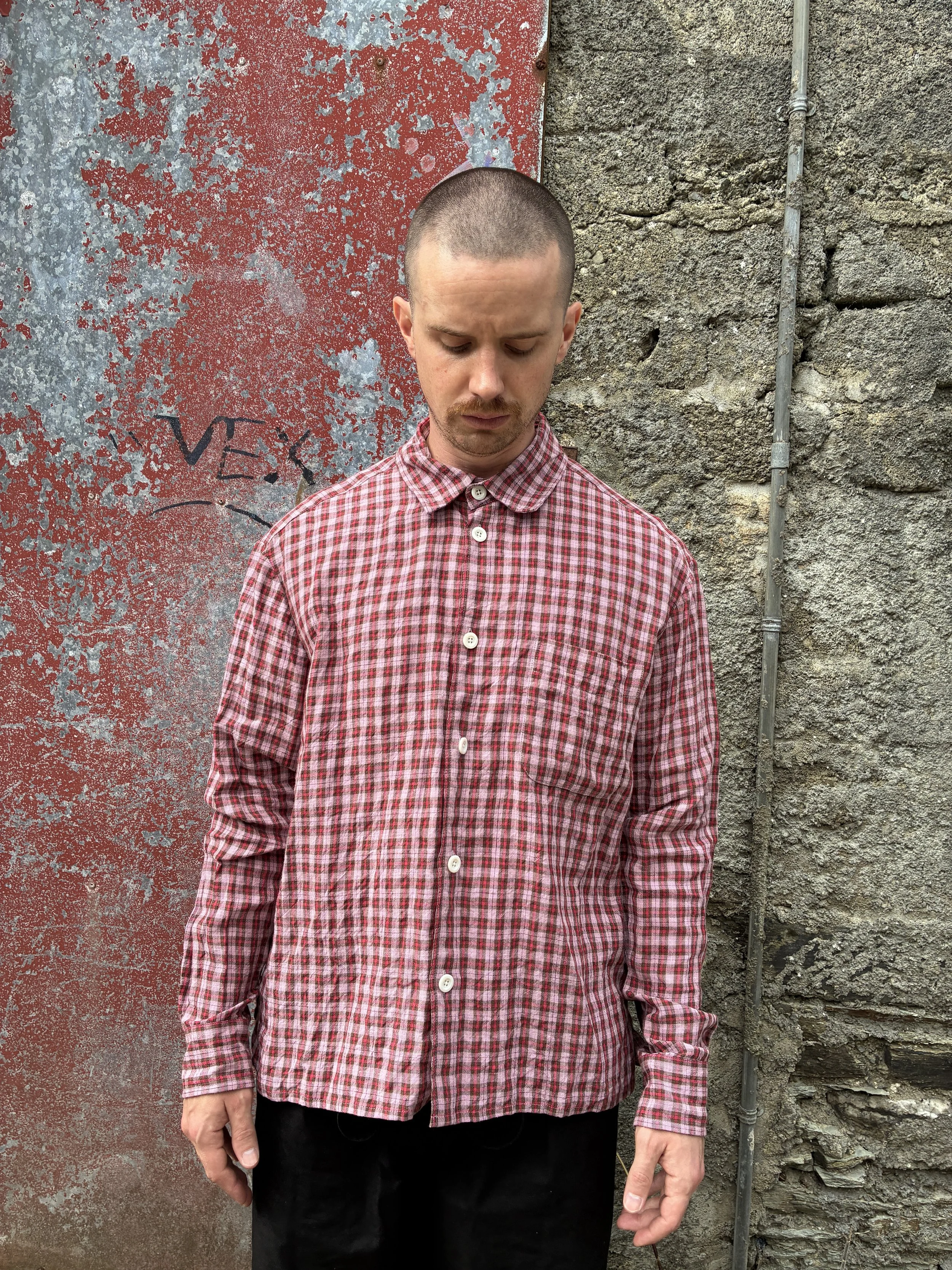 Man wearing Conkers Sunrise Relaxed Farmer Shirt in front of red wall