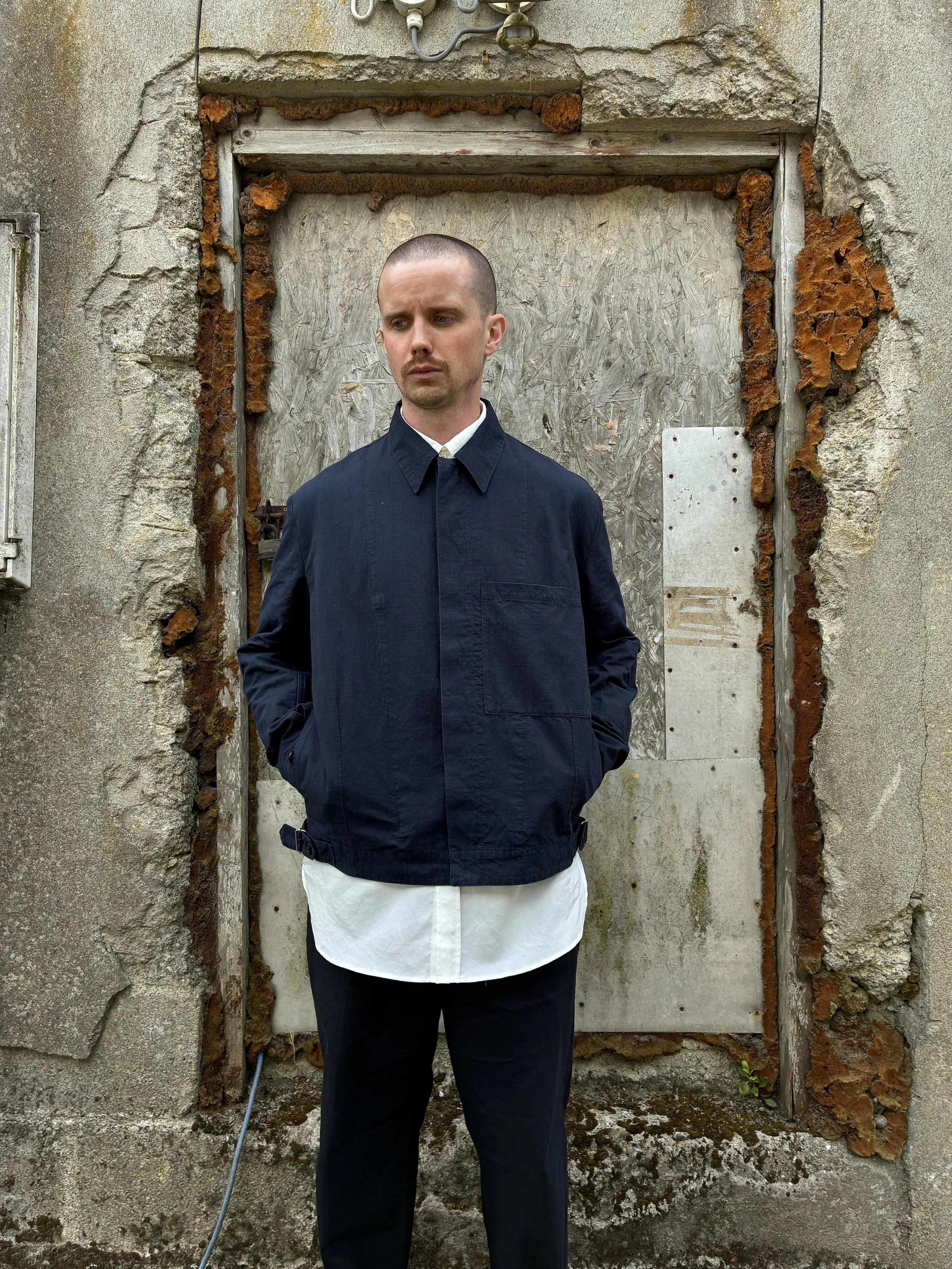 Man in front of wall wearing 1st PAT-RN Navy Camden Jacket
