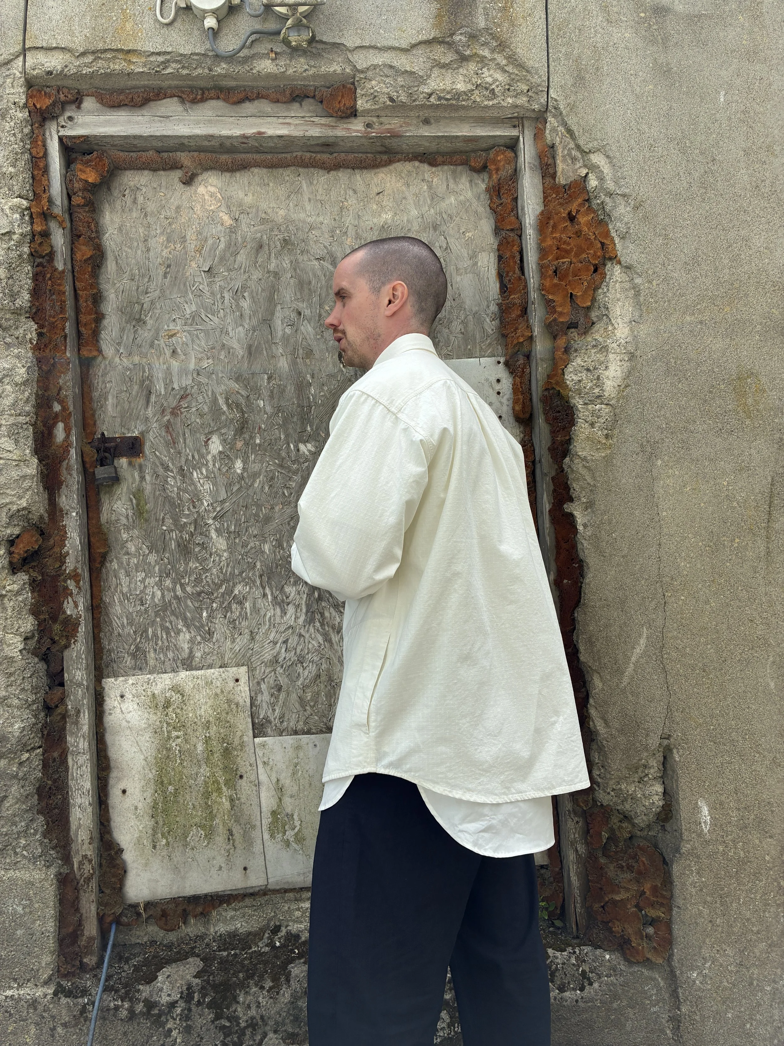 Side profile of Man in front of wall wearing Off-White Ecru 1st PAT-RN Sumatra Overshirt