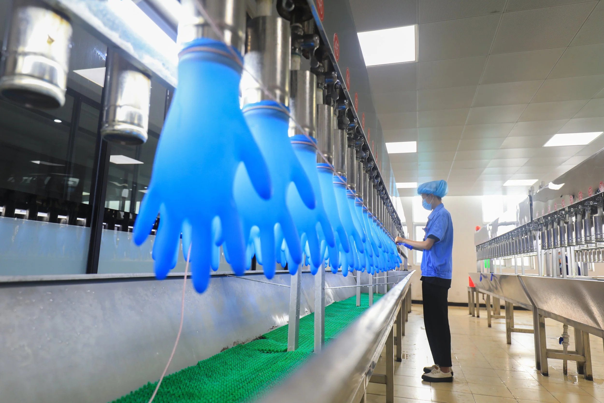 Assembly line in a factory with blue gloves