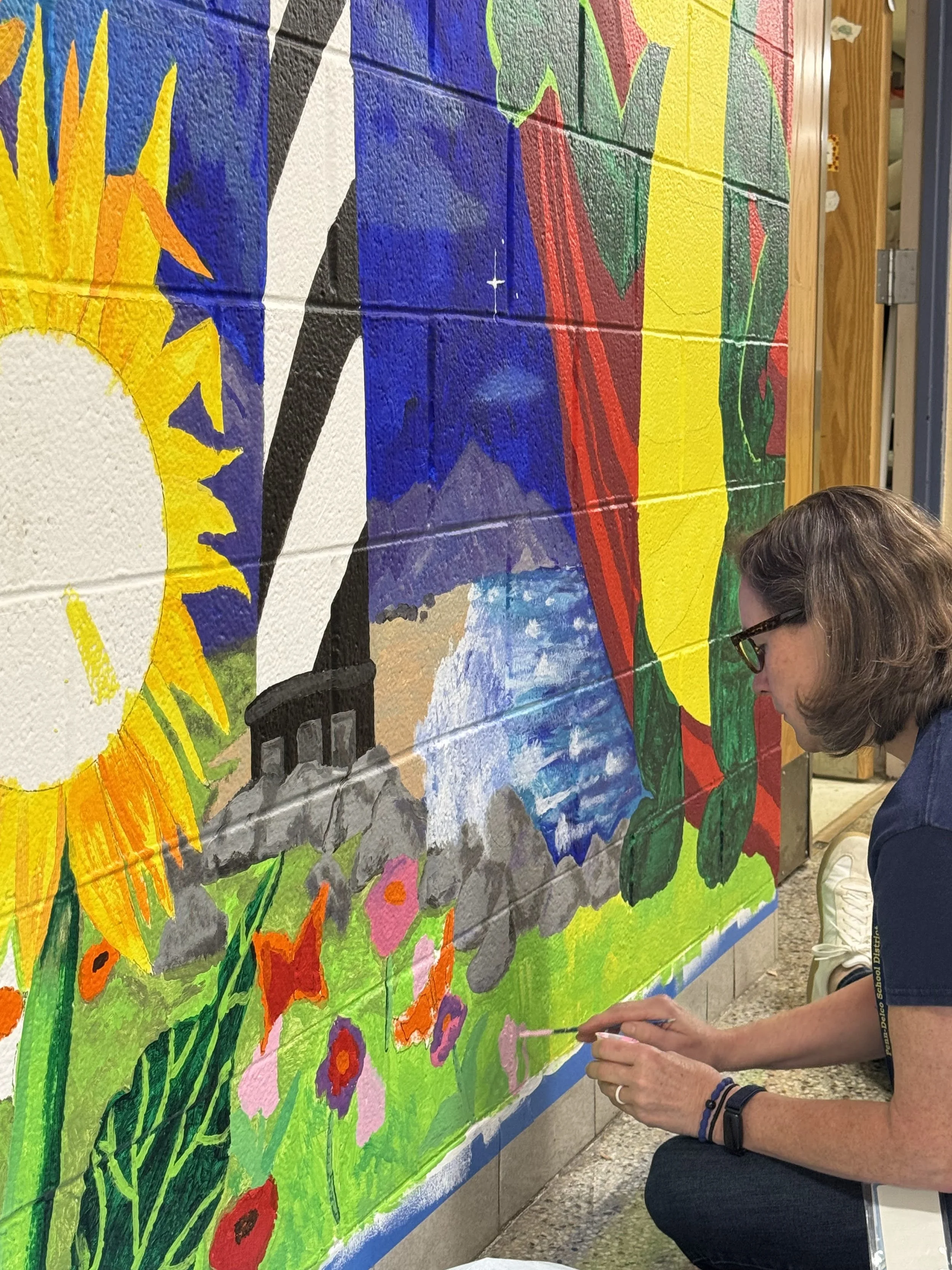 Staff member painting on the mural, all staff were invited to paint!