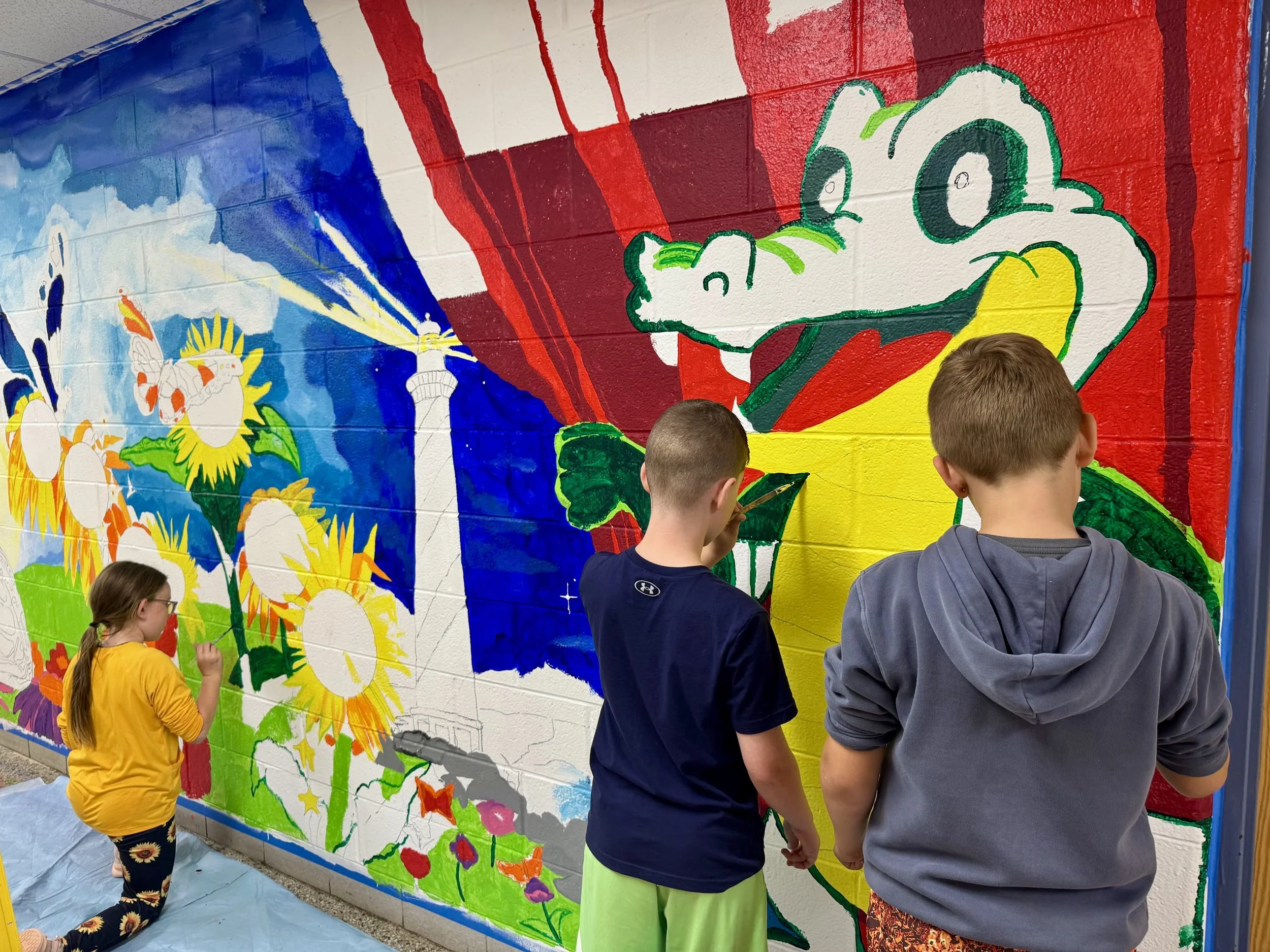 Students painting sections of the mural