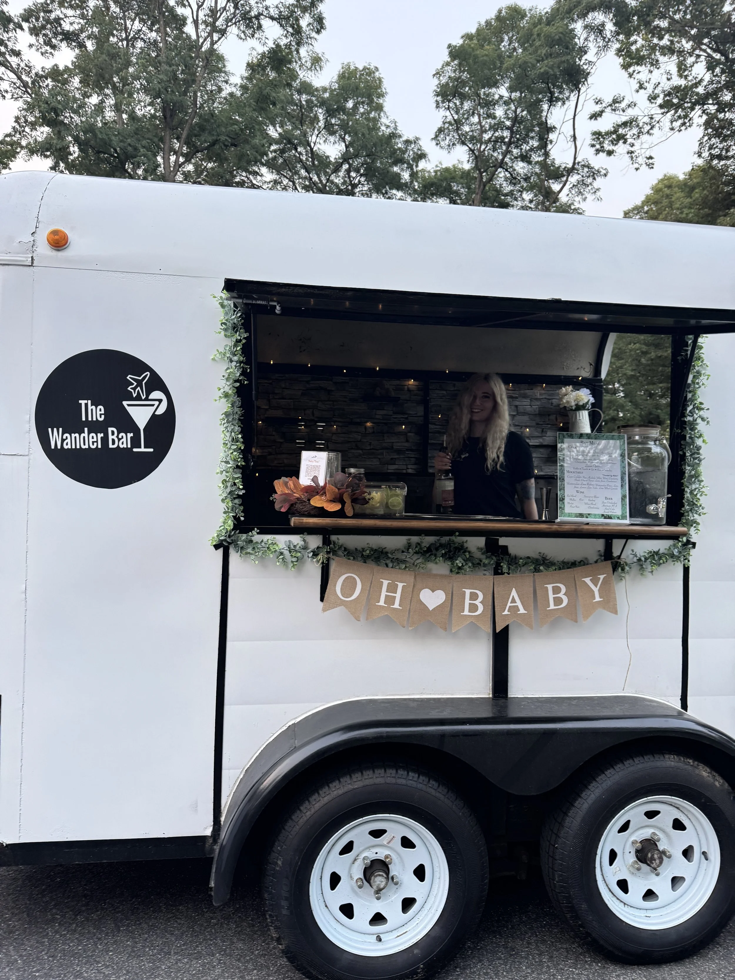Event bartender serves cocktails out of mobile horse trailer bar at baby shower in Manchester New Hampshire