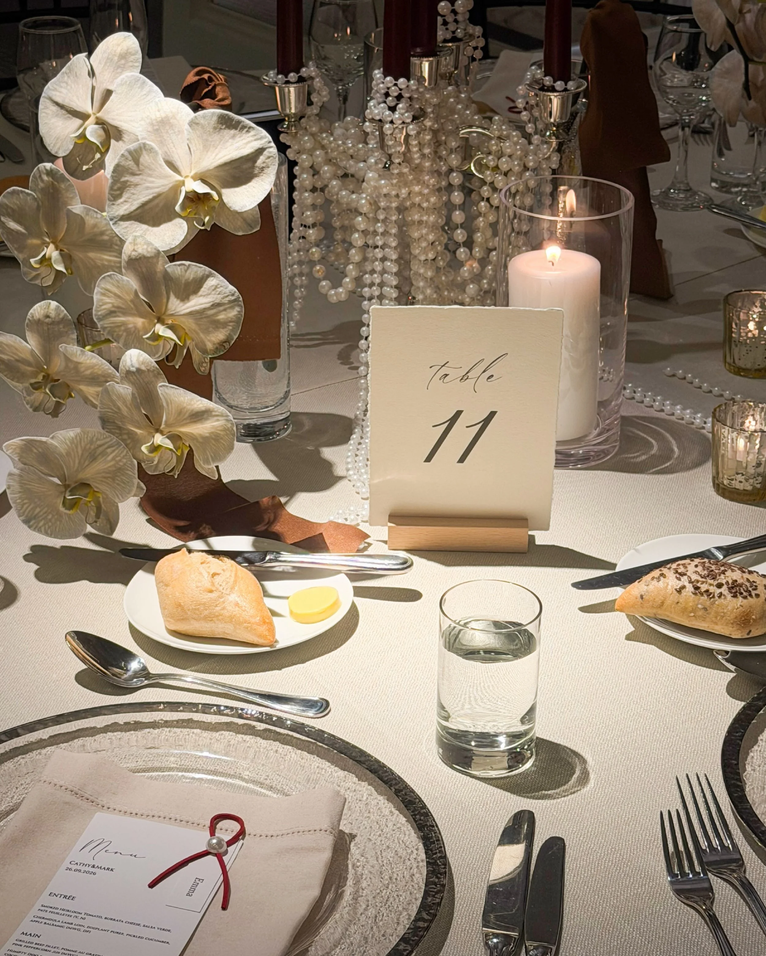 Pearls catch the light. Orchids soften the silhouette. Candles bring the warmth.

Each detail has a role.

Together, they give this quiet corner its own presence.

#styledbyjuno #sydneywedding #sydneyweddingstylist #weddingdetails #orchidwedding