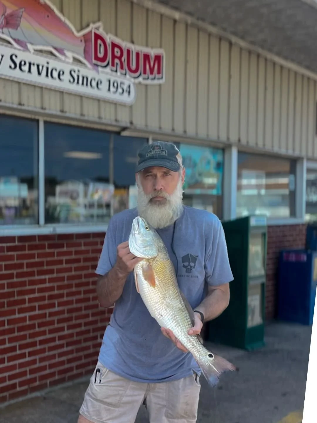 Mr. Voss with a puppy drum out front of the old Red Drum convenience store 🐟

Buxton is changing, but some things never will &mdash;
🚙 sand on the floorboards
🧥 wet waders by the door
🎣 and red drum that keep on running

That&rsquo;s the Outer Ba