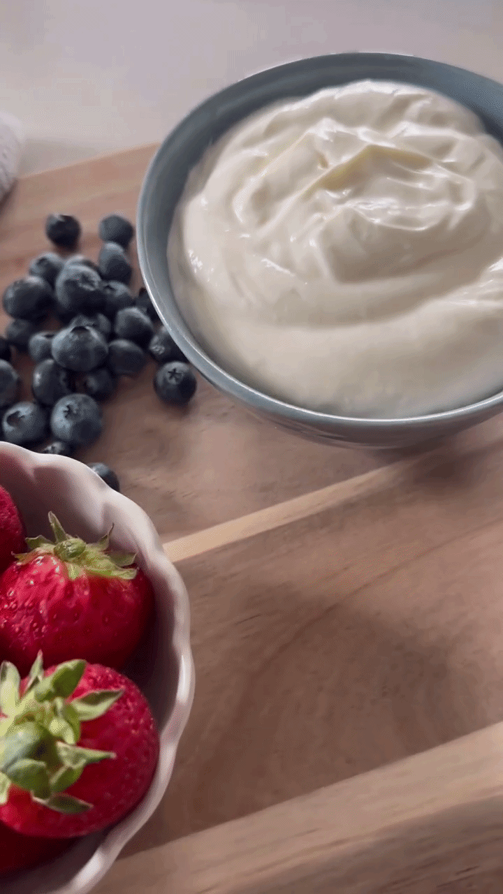A gray bowl filled with creamy whipped skyr dip next to fresh blueberries, with text overlay reading "A CUP OF SKYR, A".