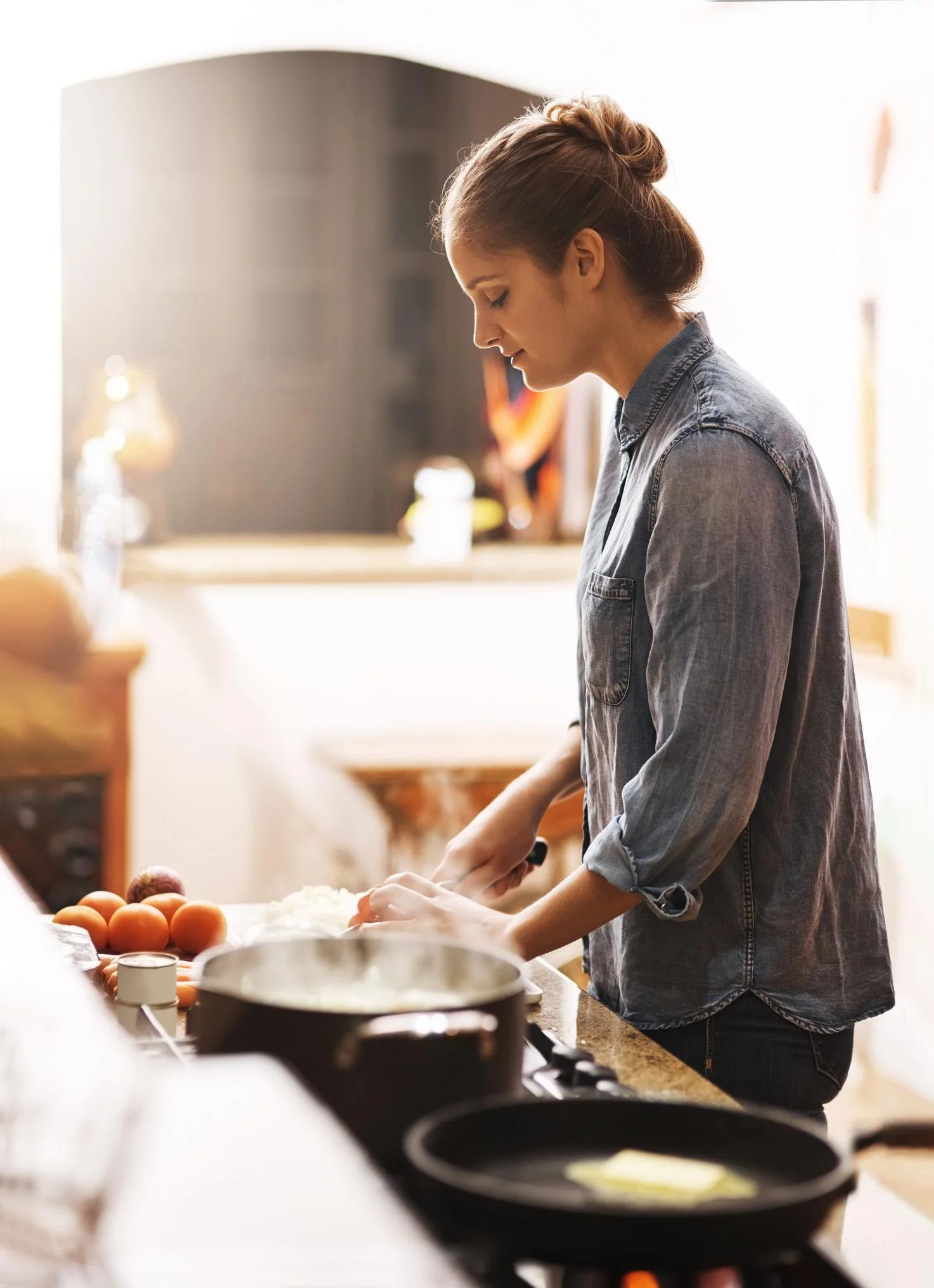 A female cooking in a kitchen.