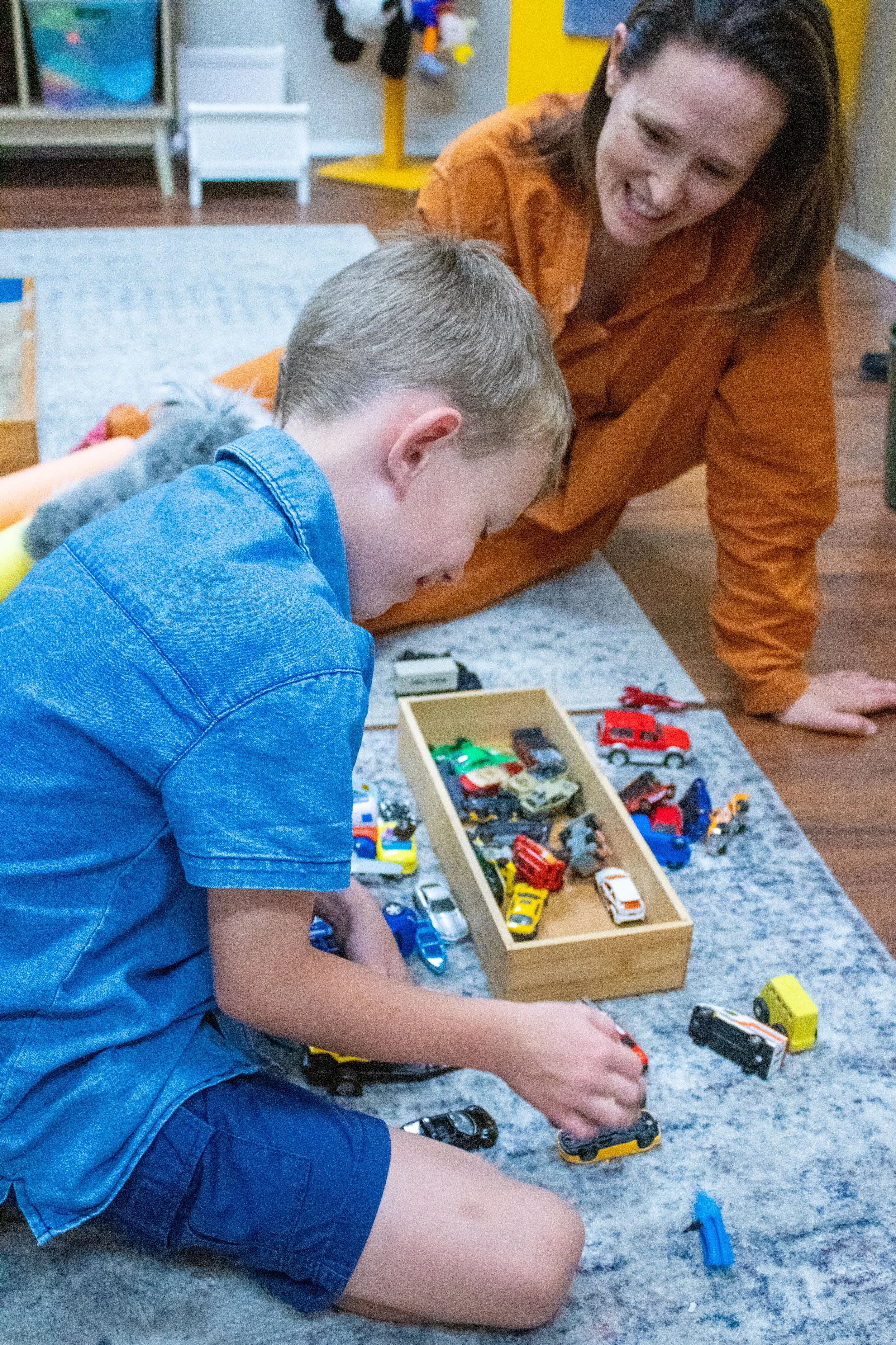 Boy participating in a play therapy session with a female therapist.