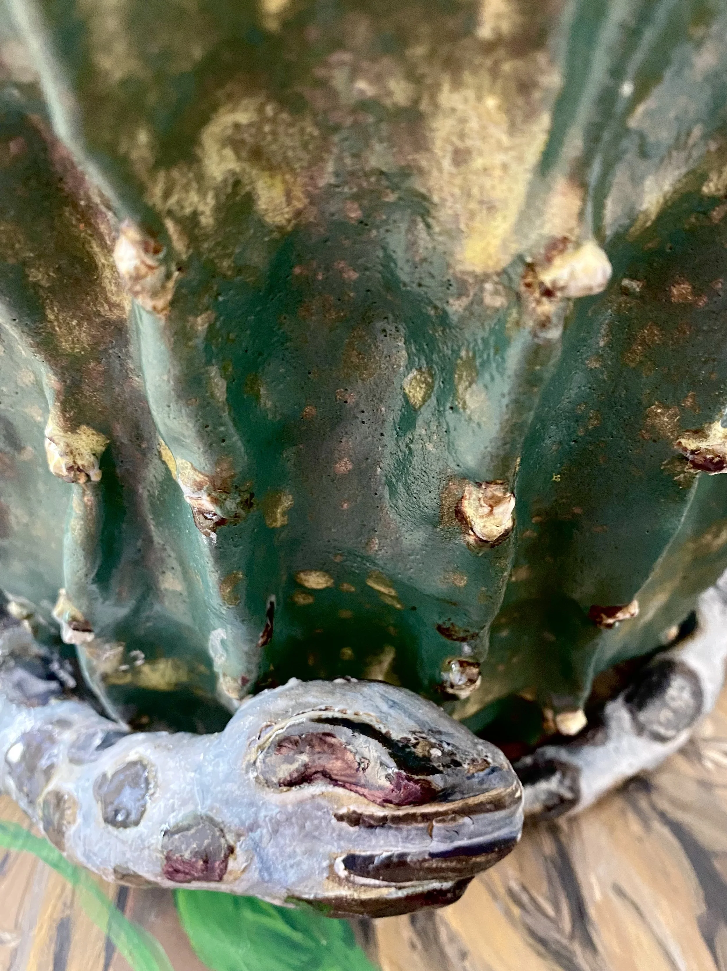 Close-up of a vintage dragon-shaped fountain with green patina and weathered details, with a dragon's head sculpture at the base.