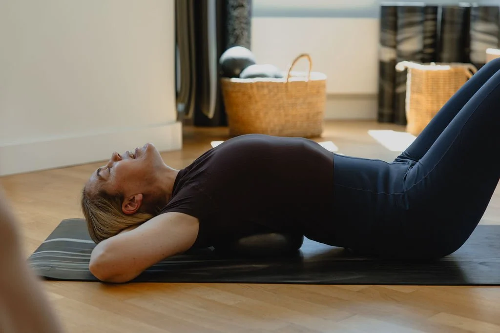 A client practicing Pilates independently on a mat