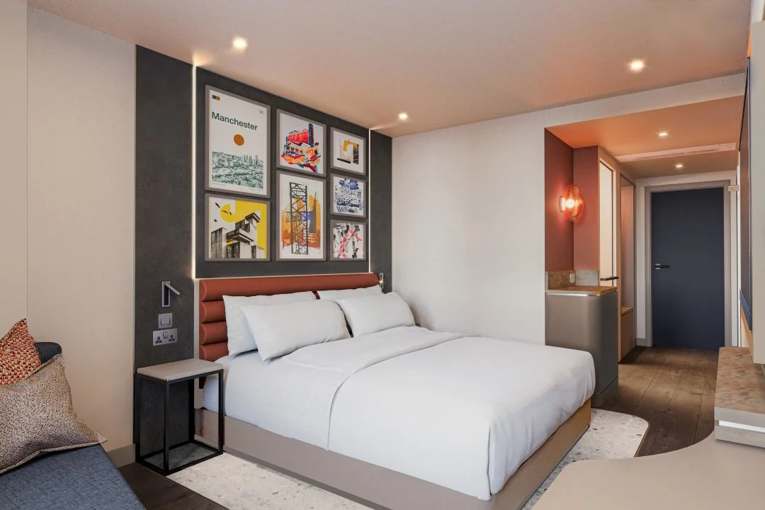 Guest room interior at Hampton by Hilton Manchester City Centre, designed by SpaceInvader, featuring a bold headboard, Manchester-inspired artwork, and warm contemporary finishes.