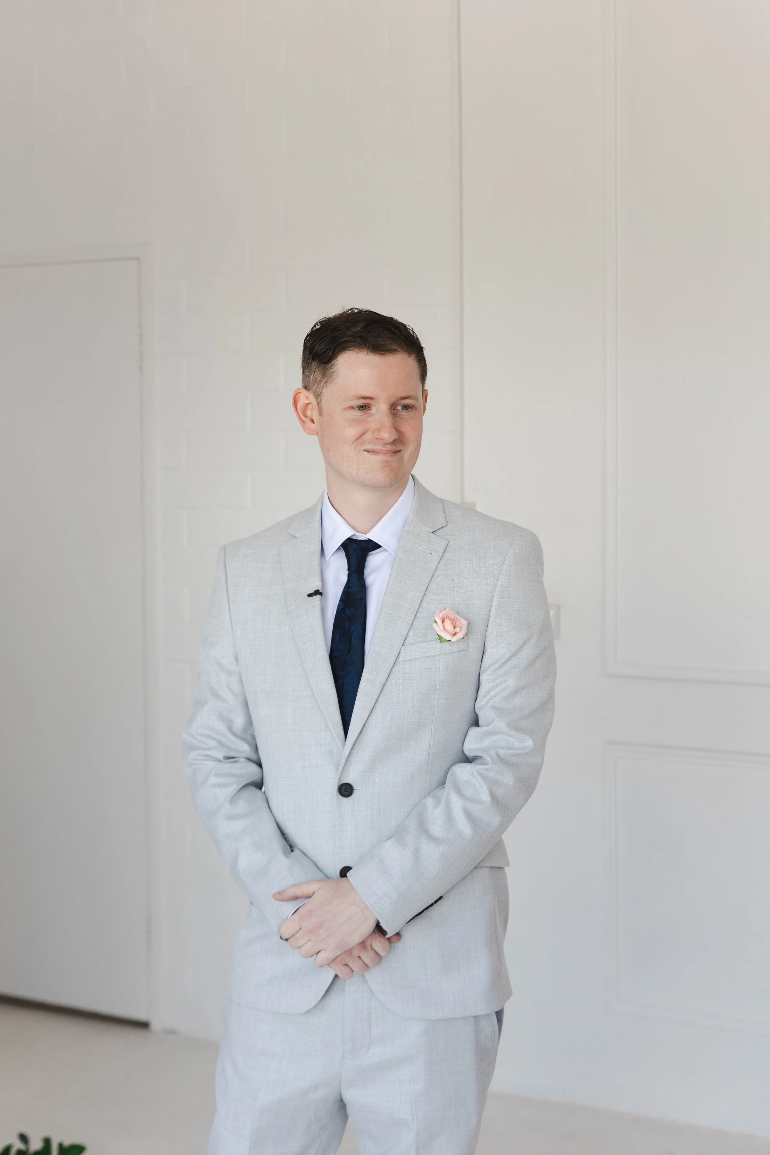 Shannon & Jarred's wedding at Faithwood Chapel – groom in a light grey suit with a pink boutonniere