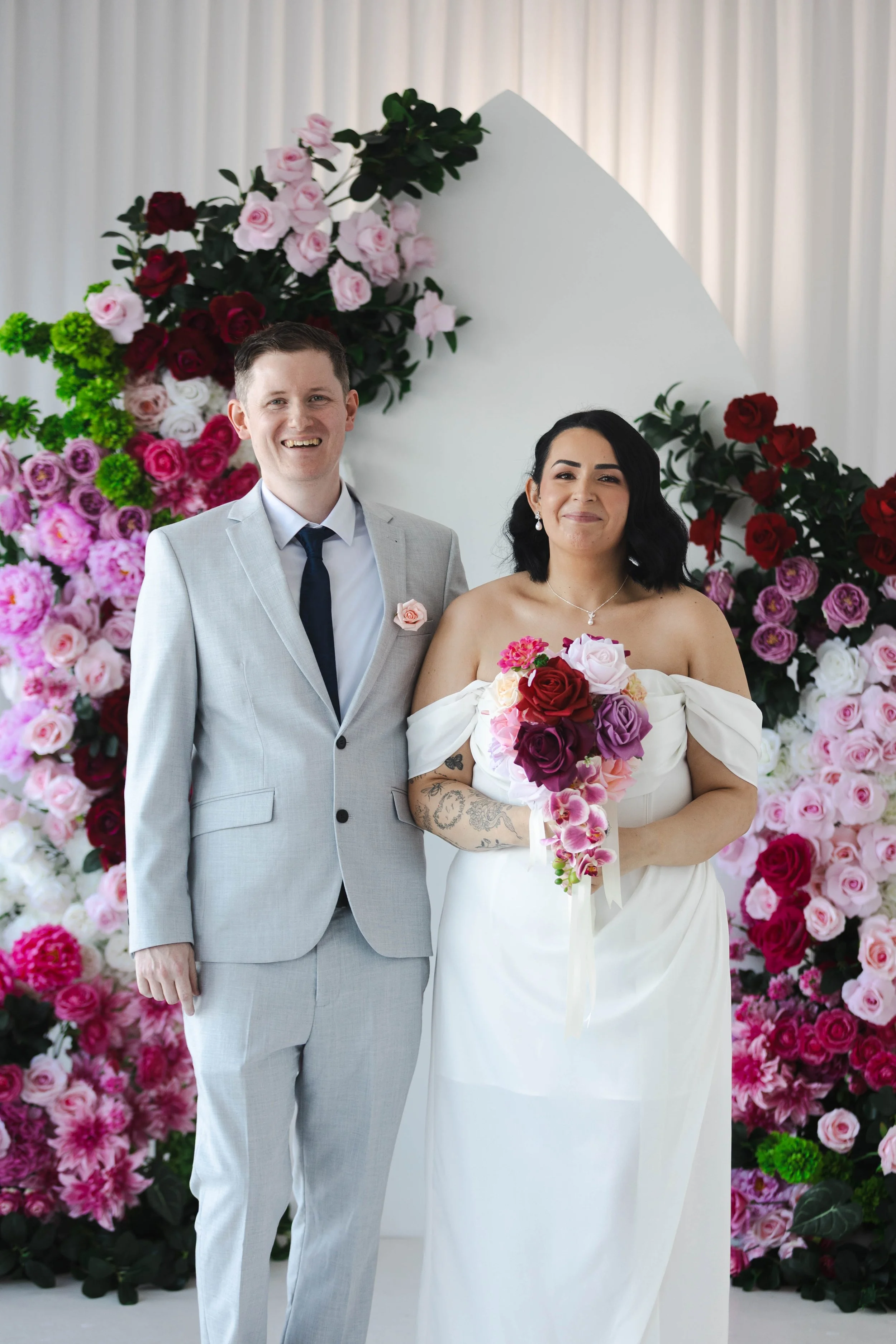 Shannon & Jarred's wedding at Faithwood Chapel – newlyweds in front of the floral backdrop